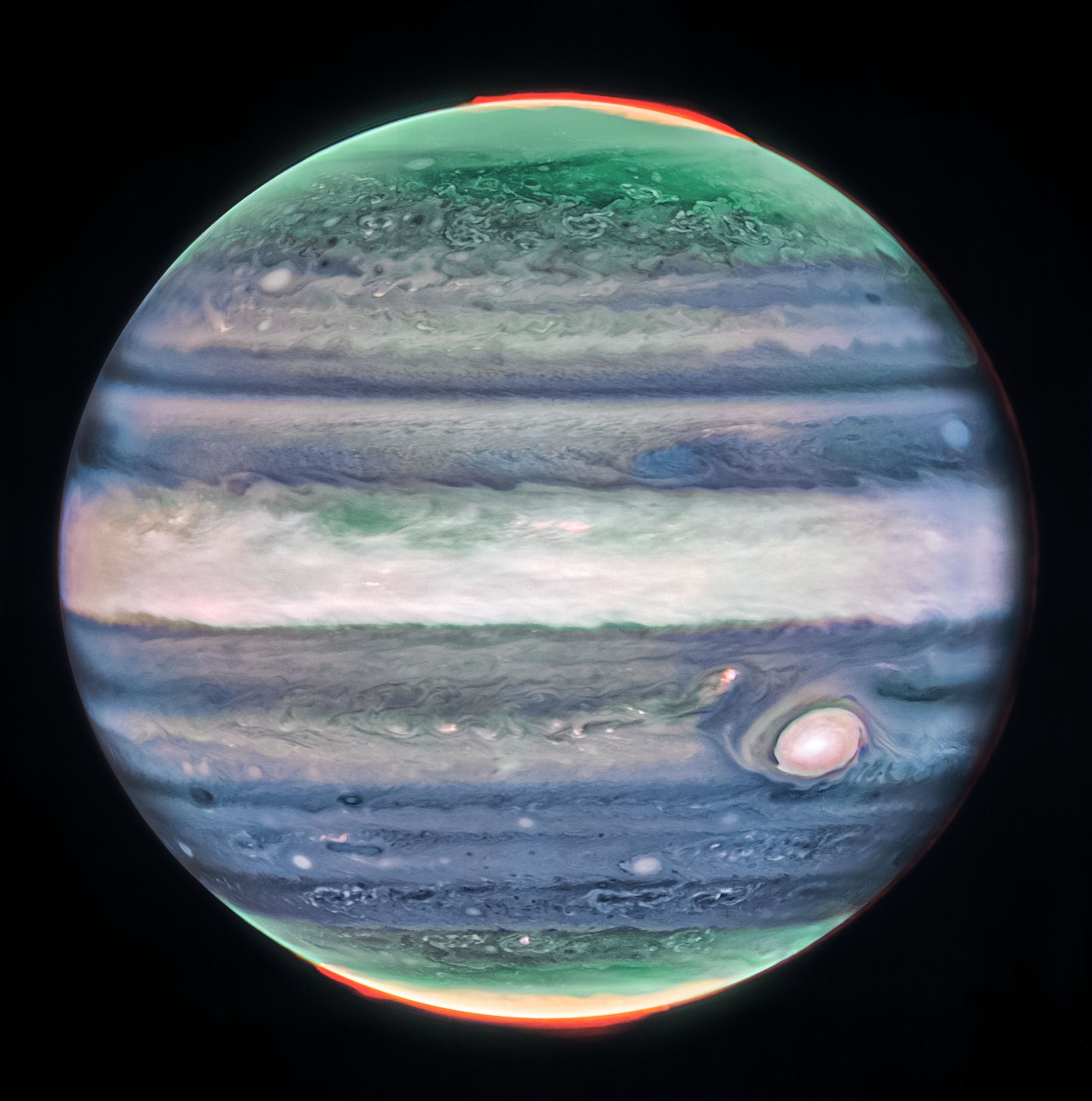 Esta imagen de Júpiter tomada por la cámara de infrarrojo cercano (NIRCam) del telescopio espacial James Webb de la NASA muestra los impresionantes detalles del majestuoso planeta en luz infrarroja. En la imagen, el brillo indica una gran altitud. Las numerosas “manchas” y “rayas” de color blanco brillante son probablemente las cimas de nubes de tormentas convectivas condensadas que están a muy gran altitud. Las auroras, que aparecen en rojo en la imagen, se extienden a mayores altitudes sobre los polos norte y sur del planeta. Por el contrario, las cintas oscuras al norte de la región ecuatorial tienen poca cubierta de nubes.