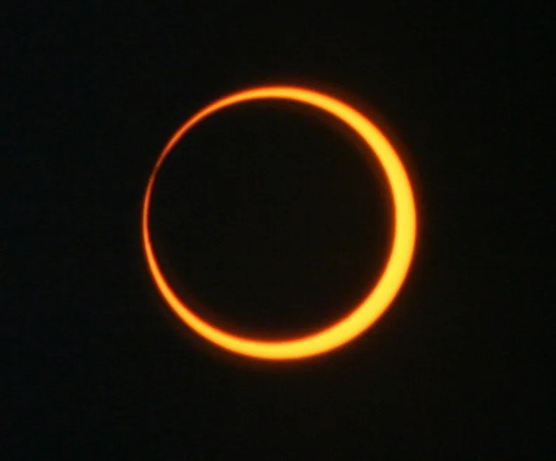 Imagen de un eclipse solar anular, en la que se ve a la Luna tapando parcialmente al Sol. El fondo es negro.