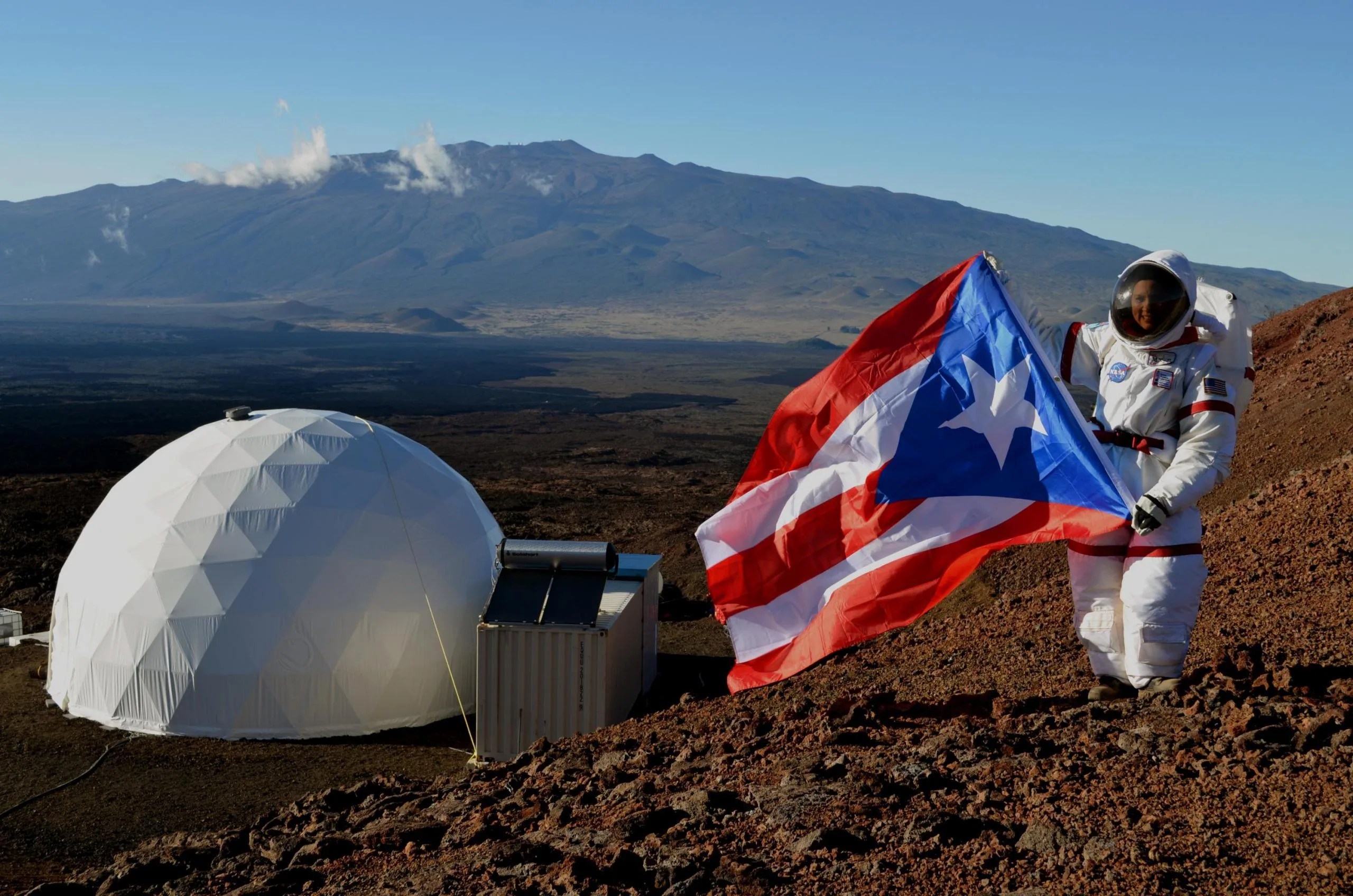La puertorriqueña Yajaira Sierra-Sastre, del Centro de Investigación Glenn de la NASA en Cleveland, Ohio, junto al domo que fue su hogar durante cuatro meses. En 2013, Sierra-Sastre participó de una misión simulada en Marte del programa HI-SEAS, financiado por la NASA. Créditos: Dra. Sian Proctor.
