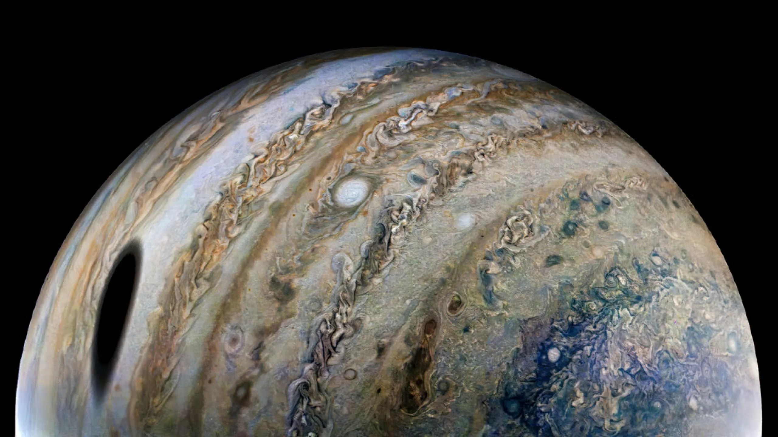 Figura A. La nave espacial Juno de la NASA capturó esta vista de Júpiter durante el 40.o paso cercano de la misión por el planeta gigante el pasado 25 de febrero de 2022. La sombra grande y oscura en el lado izquierdo de la imagen fue proyectada por la luna de Júpiter, Ganímedes.