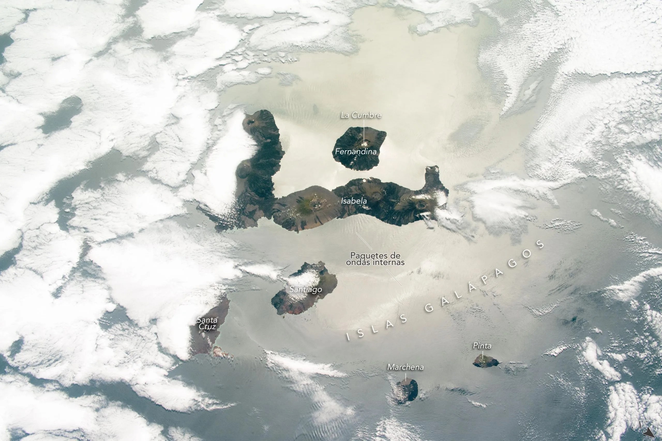 Esta fotografía, tomada el 24 de octubre de 2020 por un astronauta de la Estación Espacial Internacional, ofrece un vistazo a varias de las islas Galápagos, visibles entre las capas de nubes y acentuadas por el destello solar en la superficie del océano. Créditos: NASA/JSC