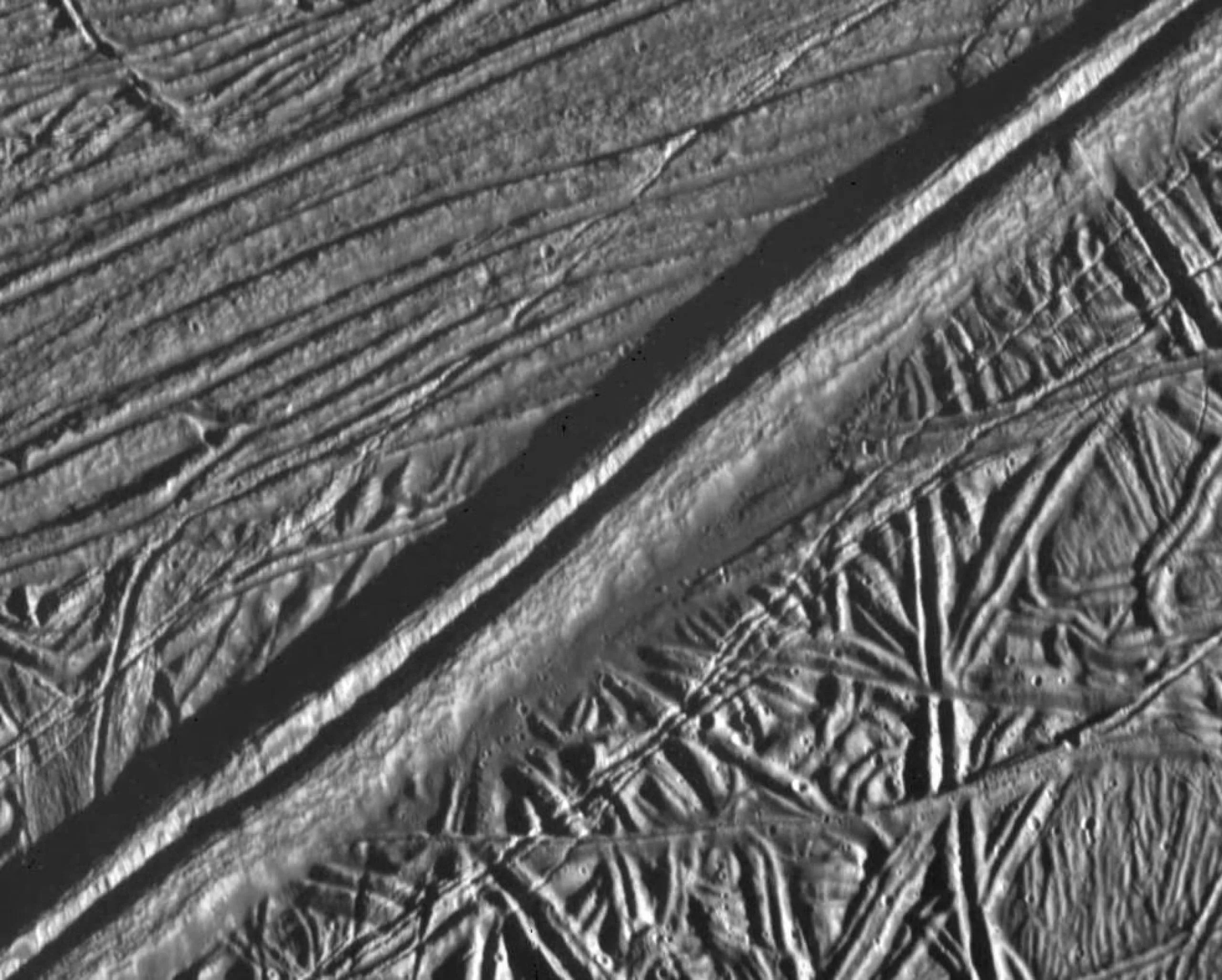 Una doble cresta que atraviesa la superficie de Europa se observa en este mosaico de dos imágenes tomadas por la sonda Galileo de la NASA durante el sobrevuelo cercano de la nave espacial el 20 de febrero de 1997. El análisis de una característica similar en Groenlandia sugiere que el agua líquida poco profunda puede ser omnipresente en la capa de hielo de la luna joviana. Créditos: NASA/JPL/ASU