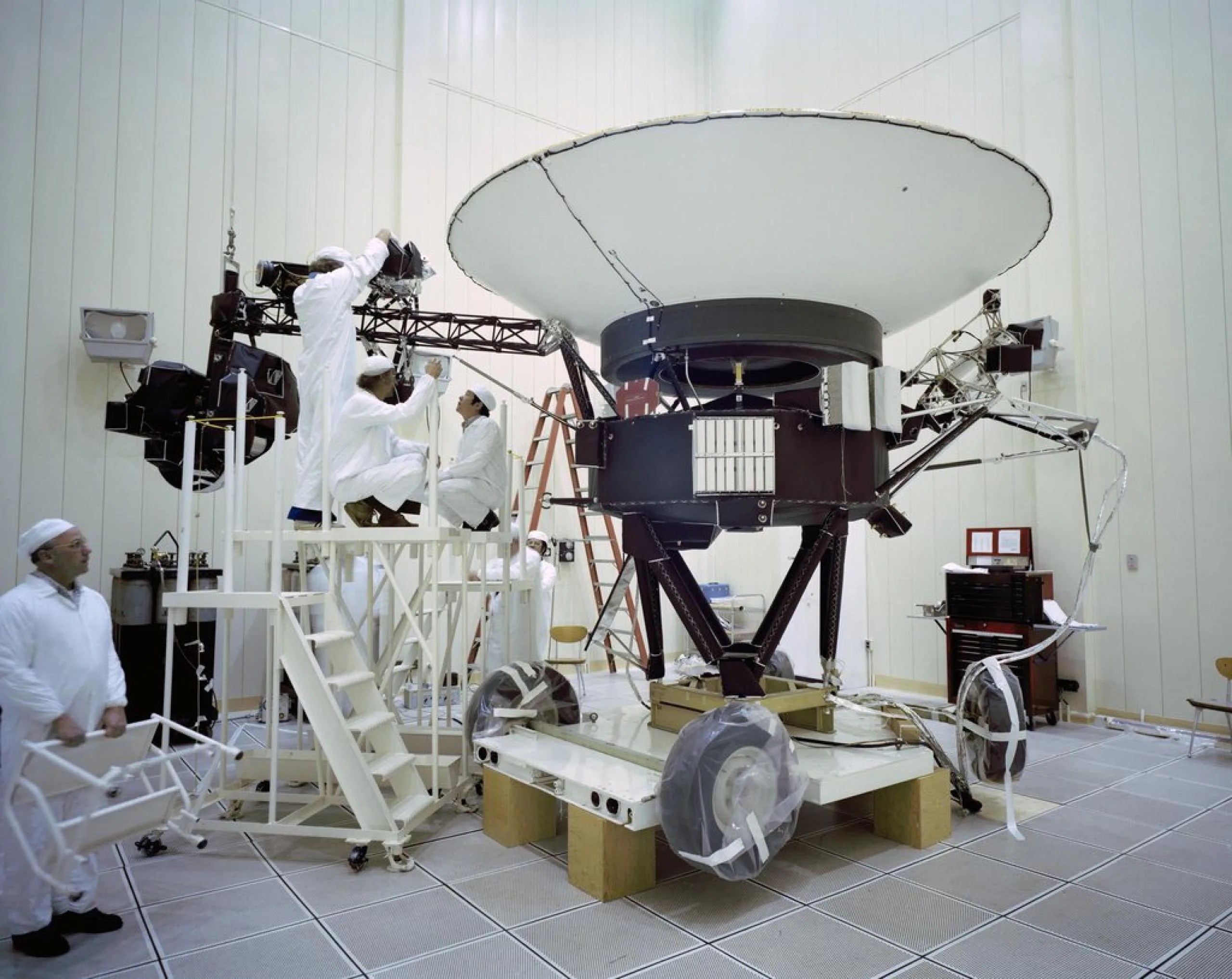 Esta imagen de archivo tomada en el Laboratorio de Propulsión a Chorro (JPL) de la NASA el 23 de marzo de 1977, muestra a los ingenieros preparando la nave espacial Voyager 2 antes de su lanzamiento ese mismo año. Crédito: NASA/JPL-Caltech.