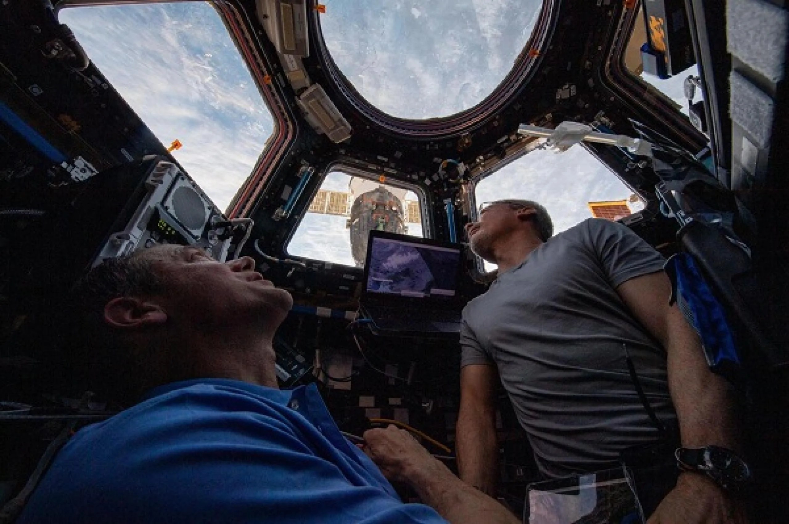 imagen de dos astronautas mirando a la Tierra desde la cupula de la estación