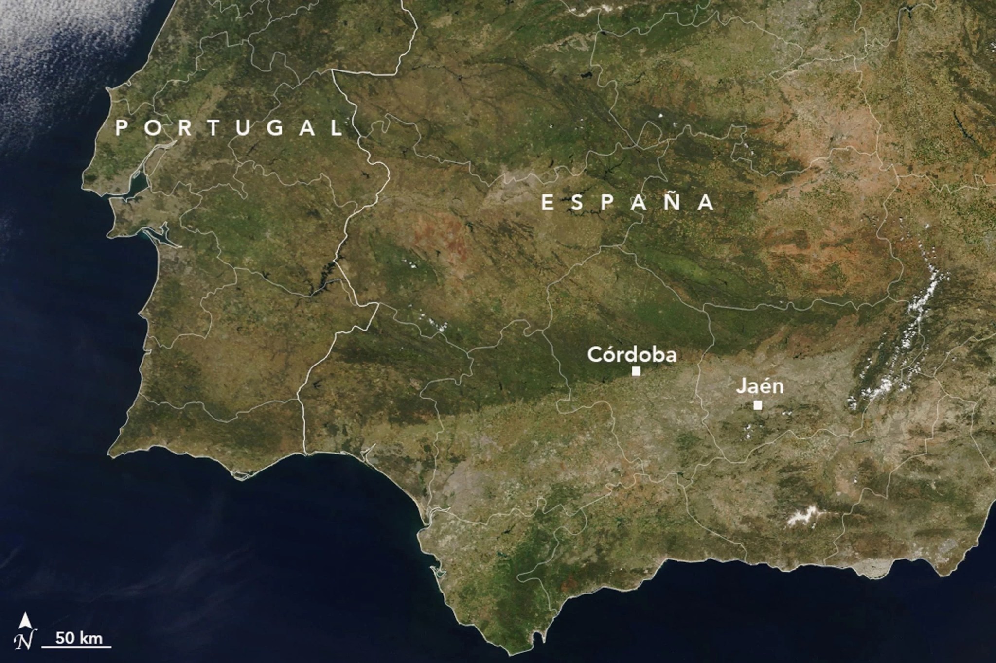 Imagen de satélite de España de mayo de 2023, durante una sequía. La zona es ahora casi toda marrón, con manchas de color marrón oscuro y gris donde hace un año había vegetación verde. El océano a la izquierda es azul oscuro, con algo de cobertura de nubes en la parte inferior derecha.