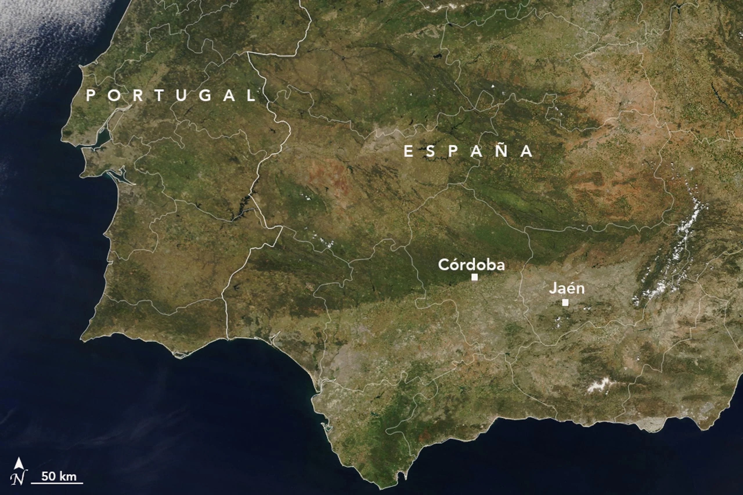 Imagen de satélite de España de mayo de 2023, durante una sequía. La zona es ahora casi toda marrón, con manchas de color marrón oscuro y gris donde hace un año había vegetación verde. El océano a la izquierda es azul oscuro, con algo de cobertura de nubes en la parte inferior derecha.