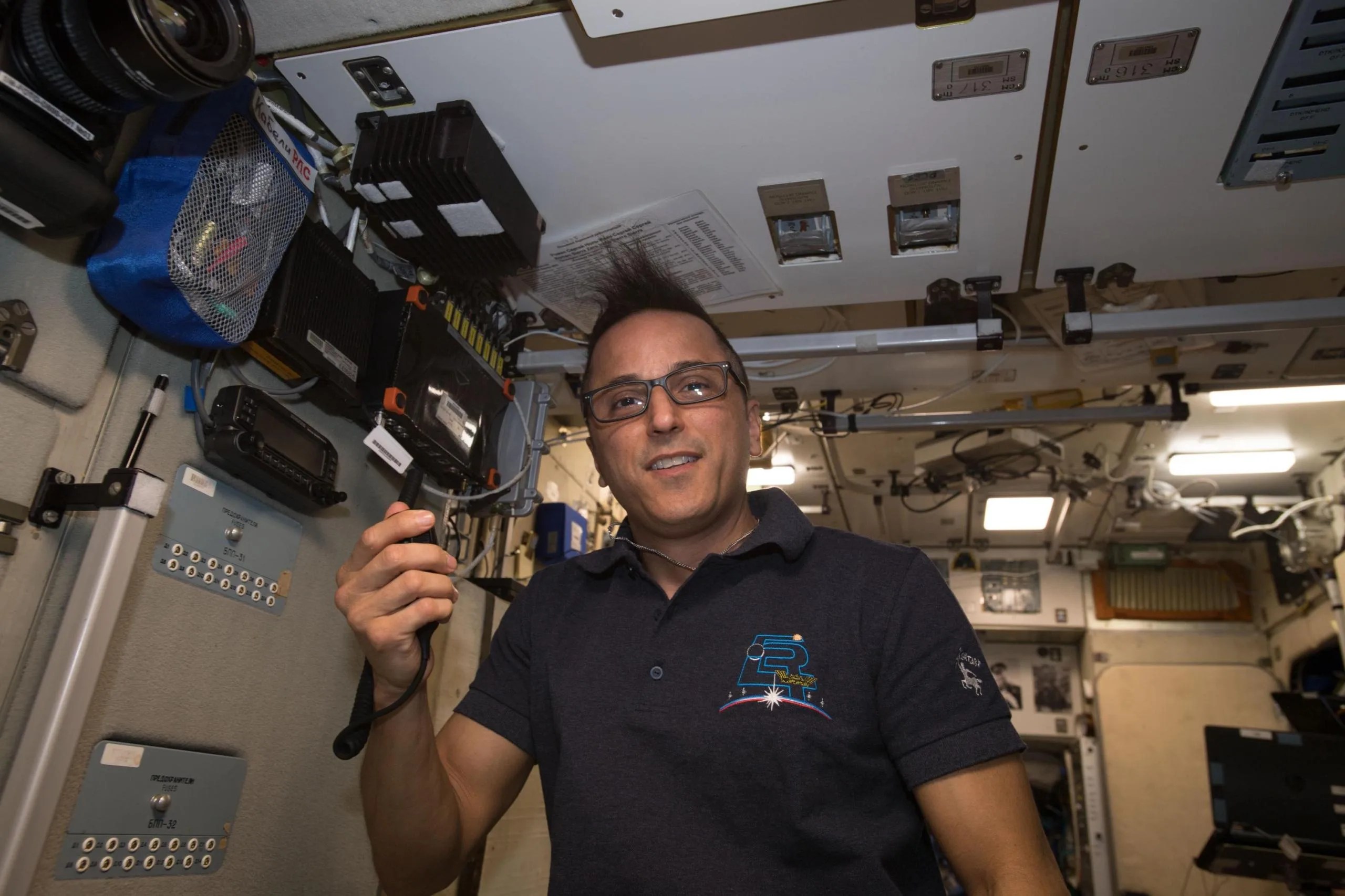 El astronauta de la NASA Joe Acabá con un transmisor de radio en mano a bordo de la Estación Espacial Internacional.