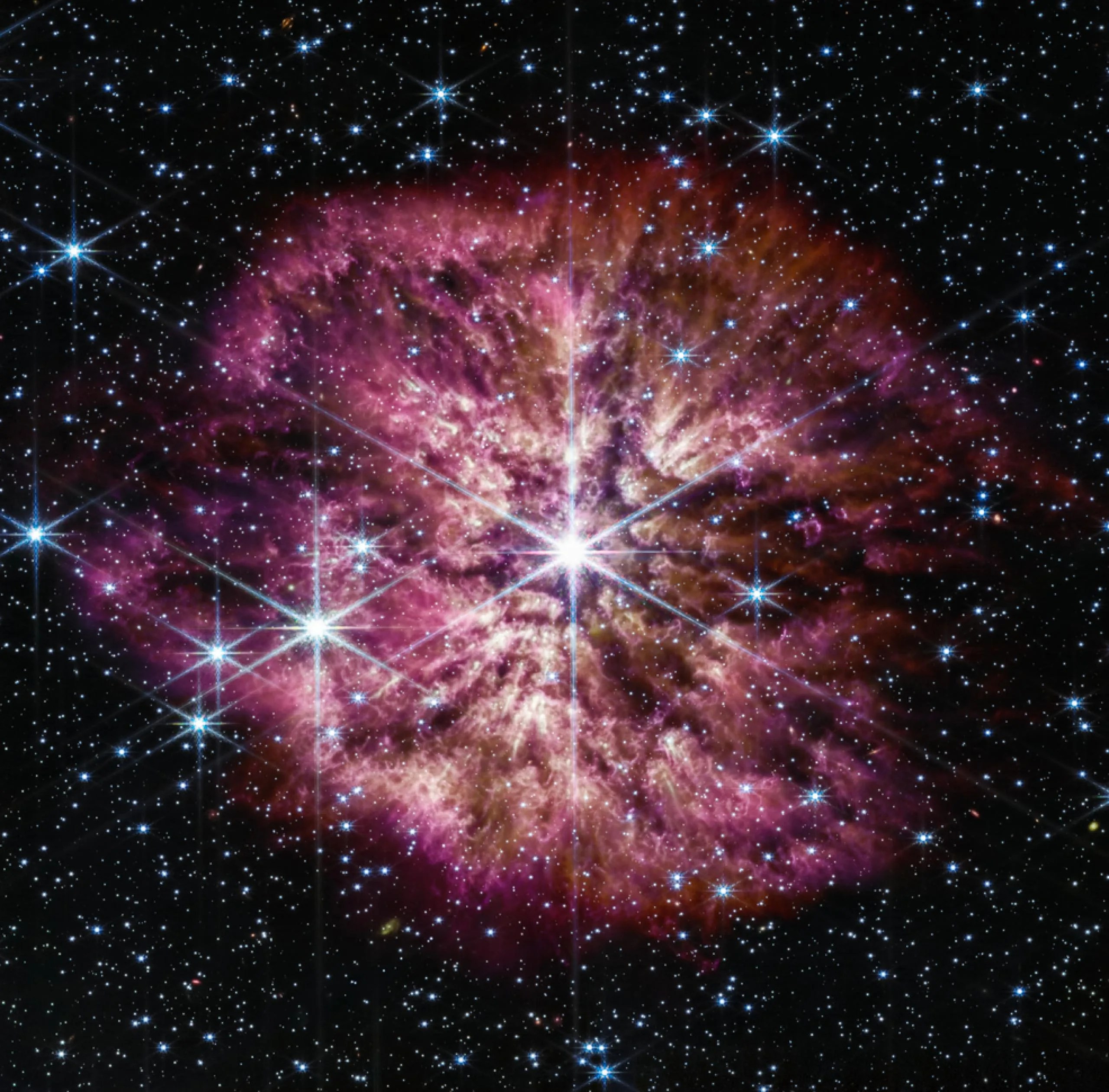 La estrella luminosa y caliente Wolf-Rayet 124 (WR 124) se destaca en el centro de la imagen compuesta del telescopio espacial James Webb, que combina longitudes de ondas de luz del infrarrojo cercano y el infrarrojo medio obtenidas por la cámara de infrarrojo cercano y el instrumento de infrarrojo medio de Webb.