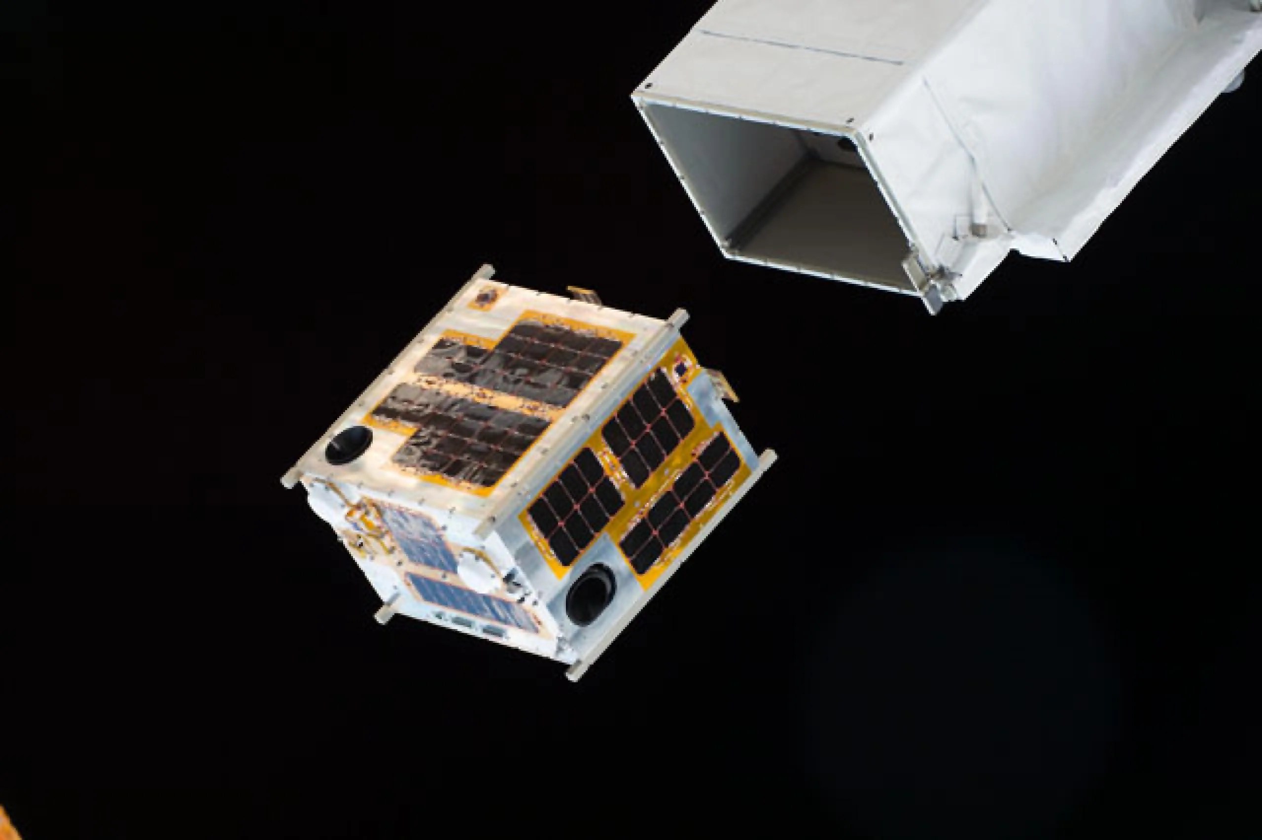 imagen de un CubeSat siendo desplegado desde la estación espacial
