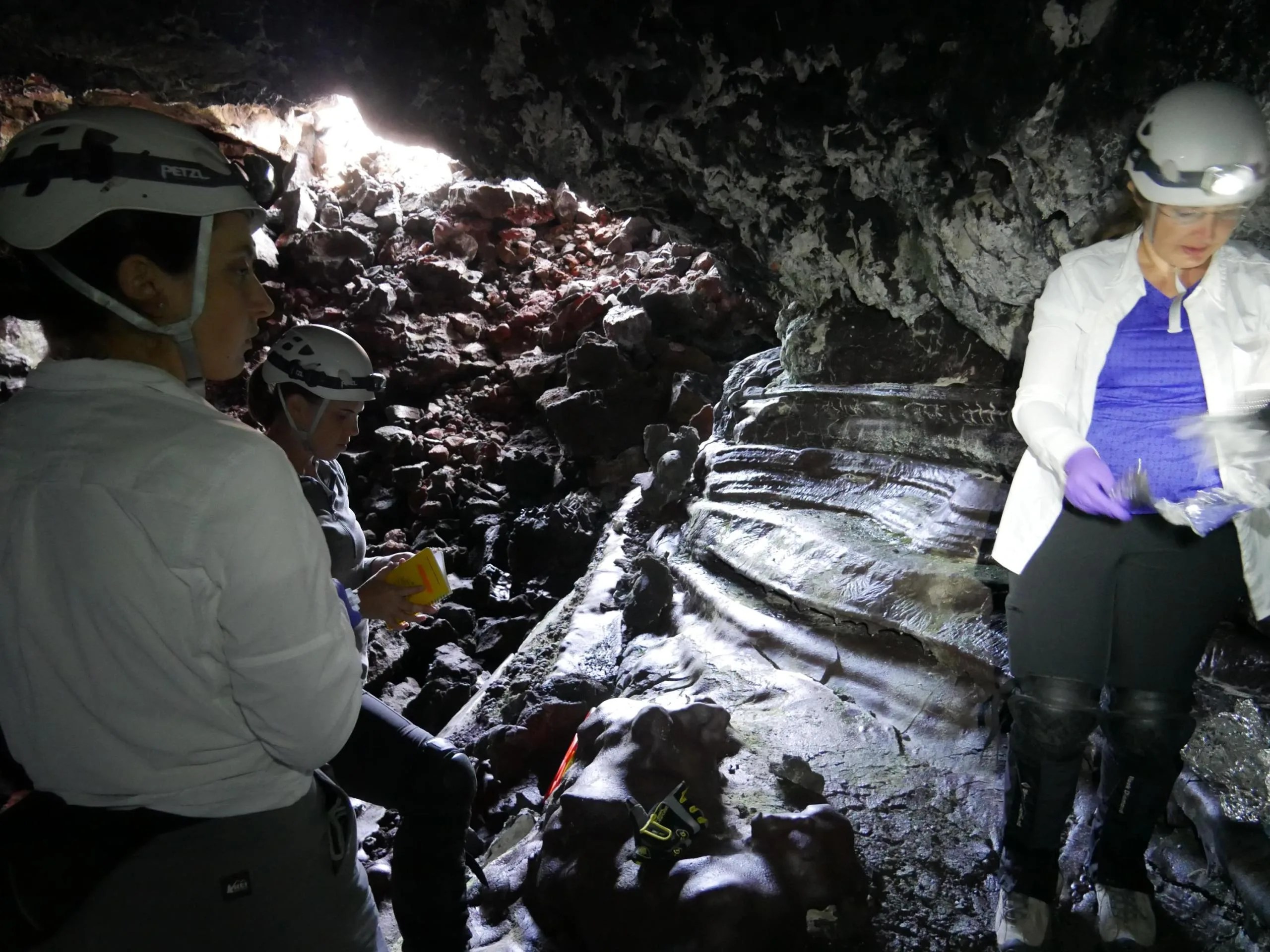 En agosto de 2019, científicos de la NASA y de otras instituciones exploraron un túnel de lava en el volcán Mauna Loa de Hawái. En esta imagen, caminan a través de pilas de escombros de rocas que se forman cuando la lava se enfría rápidamente. Estas rocas contienen vidrio que se pega a los pantalones, como un velcro afilado.