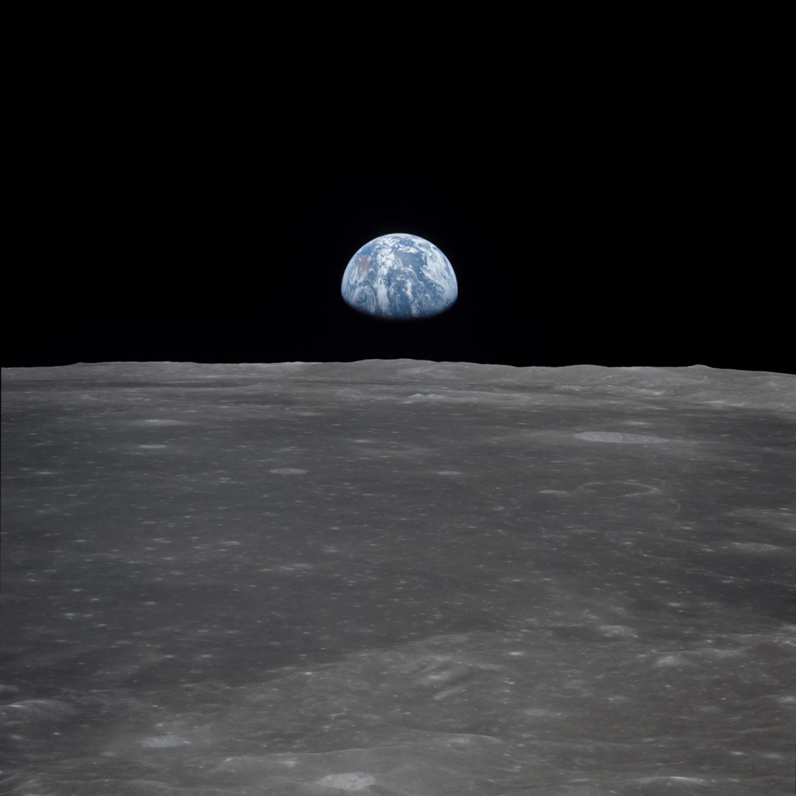 Esta es una vista captada desde la nave espacial Apolo 11, que muestra la Tierra elevándose sobre el horizonte lunar.