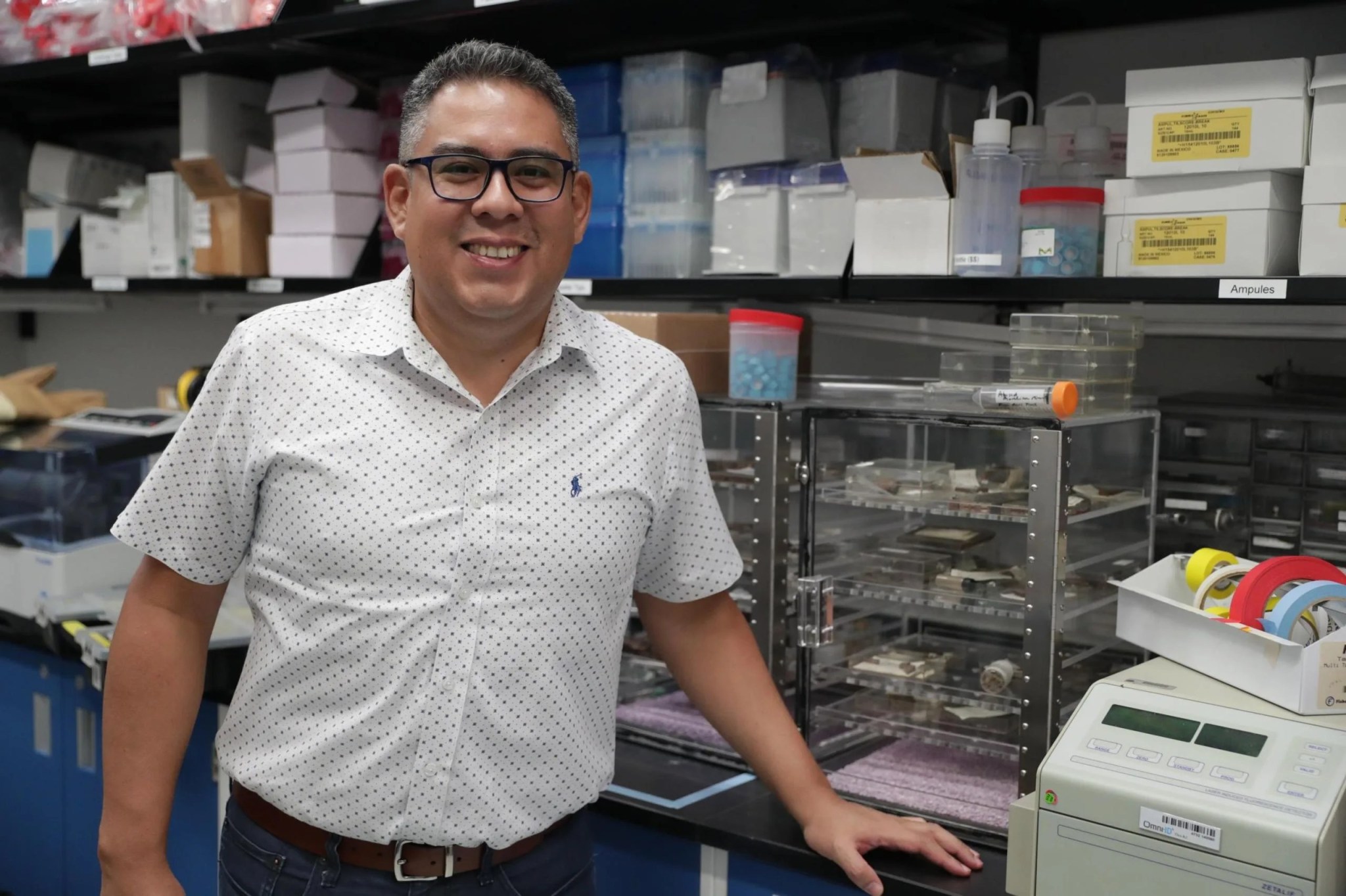 El doctor Aponte parado y sonriente en el laboratorio de química en el Centro de Vuelo Espacial Goddard de la NASA.