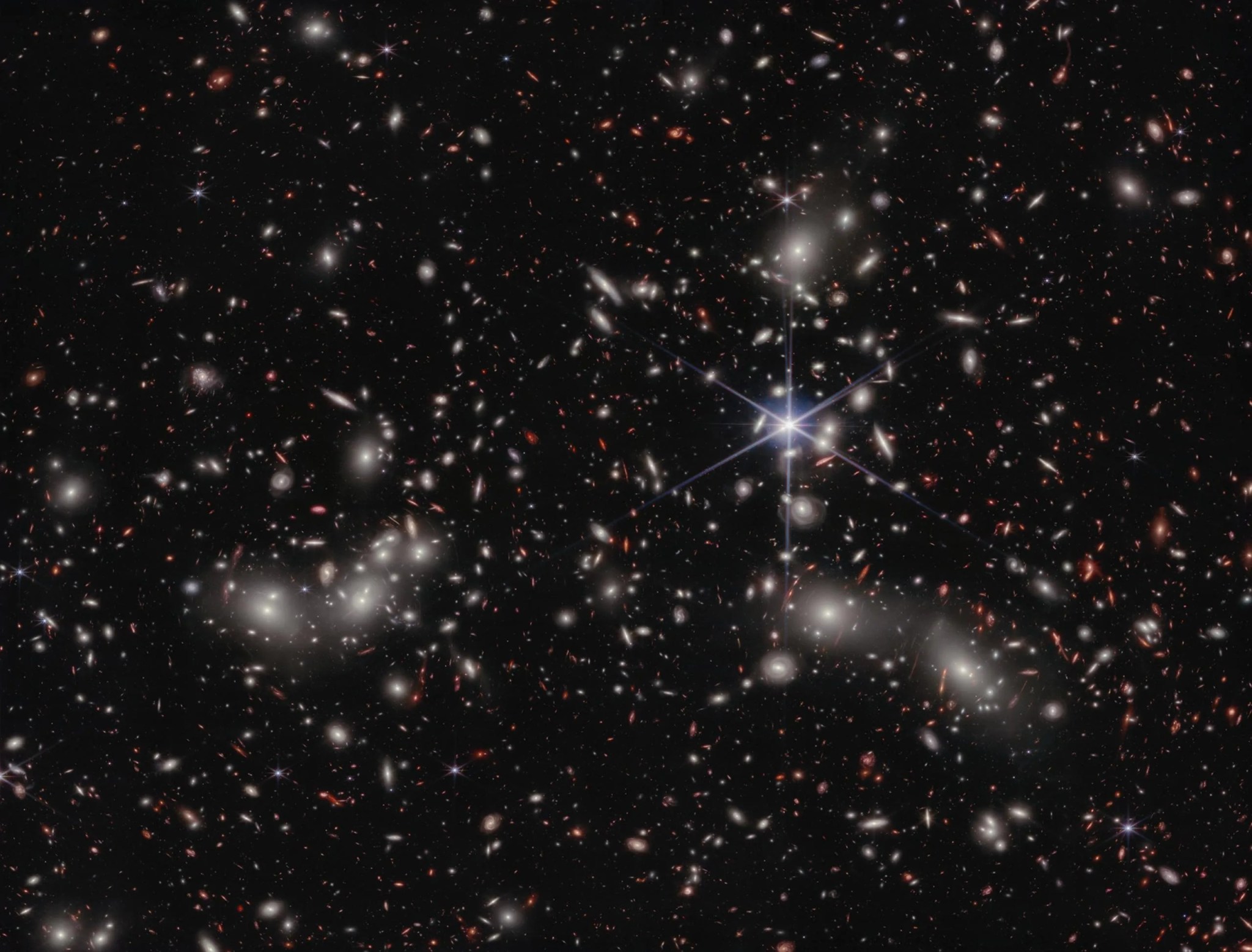 Los astrónomos estiman que unas 50.000 fuentes de luz en el infrarrojo cercano están representadas en esta imagen del telescopio espacial James Webb de la NASA. Su luz ha viajado a través de diferentes distancias para llegar a los detectores del telescopio, representando la inmensidad del espacio en una sola imagen. Una estrella en primer plano en nuestra propia galaxia, a la derecha del centro de la imagen, muestra los característicos picos de difracción de Webb.