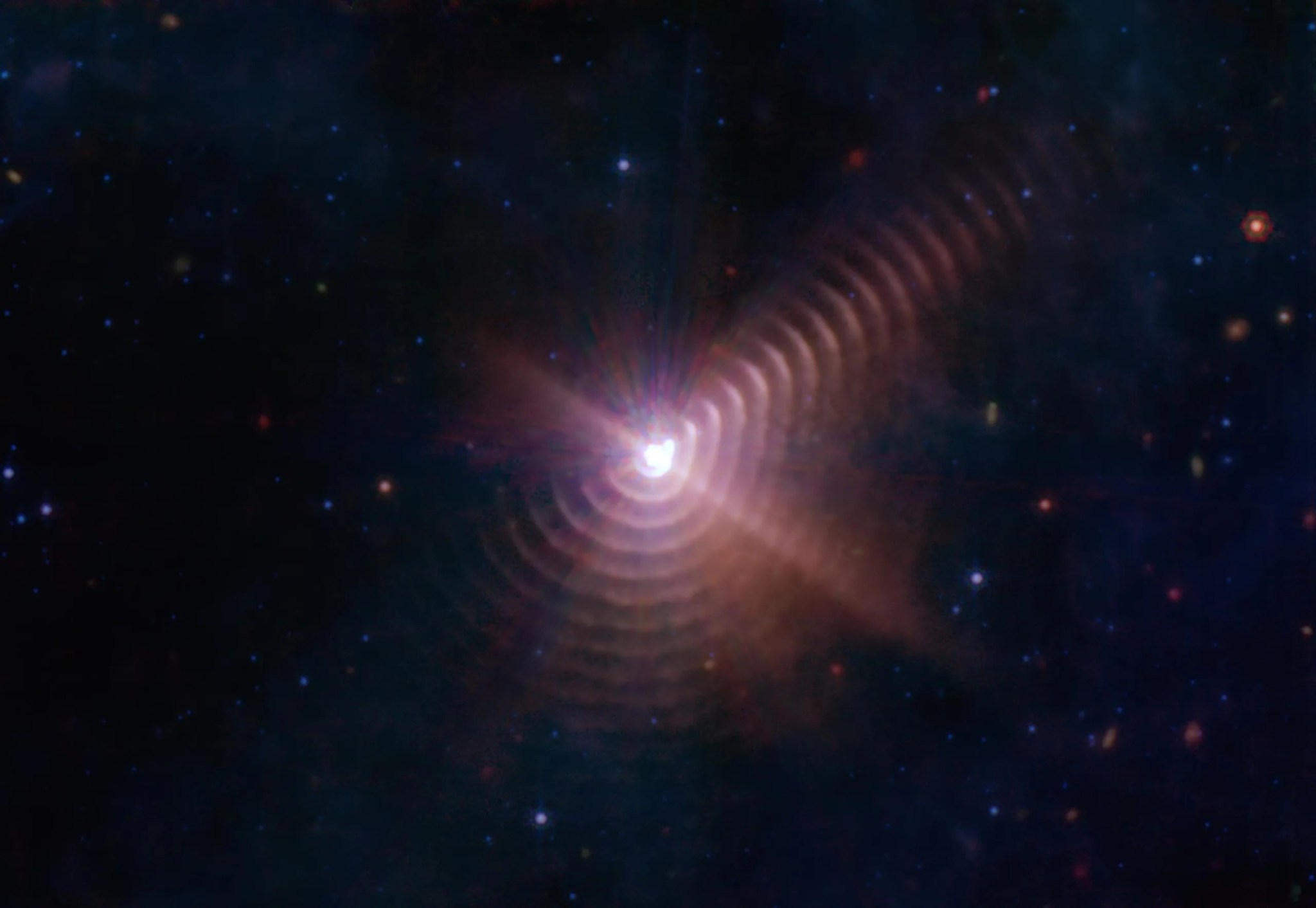 Cada ocho años, las dos estrellas Wolf-Rayet 140 producen capas de polvo que parecen anillos, como se ve en esta imagen del telescopio espacial James Webb de la NASA. Cada anillo se creó cuando las estrellas se acercaron y sus vientos estelares colisionaron, comprimiendo el gas y formando polvo. Crédito: NASA, ESA, CSA, STScI, JPL-Caltech