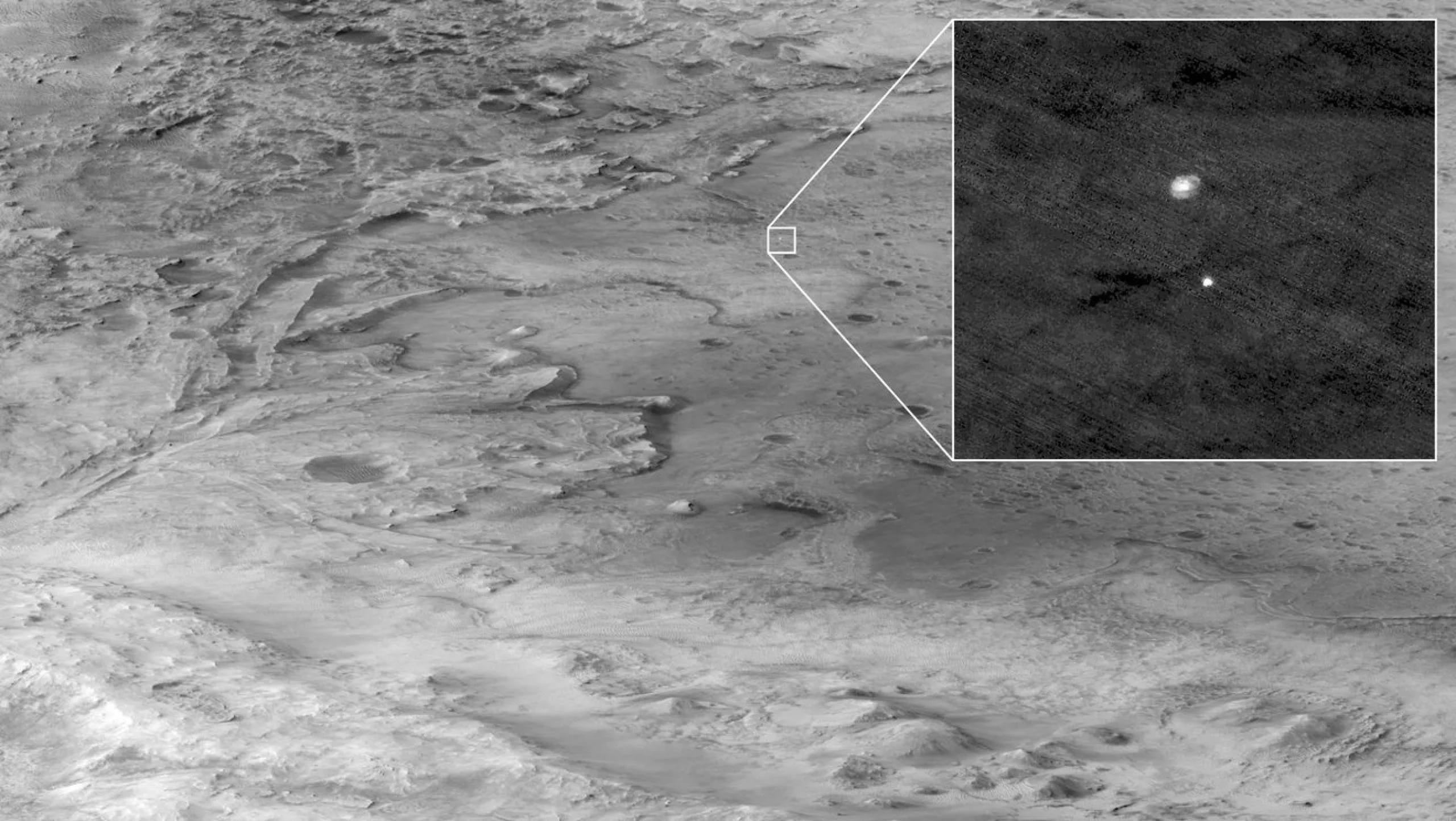 Se puede ver la etapa de descenso que sostiene al rover Perseverance de la NASA cayendo a través de la atmósfera marciana en esta imagen tomada el 18 de febrero de 2021 con la cámara HiRISE a bordo del Orbitador de Reconocimiento de Marte. Una elipse indica el lugar de aterrizaje de Perseverance. Crédito: NASA/Caltech/Universidad de Arizona