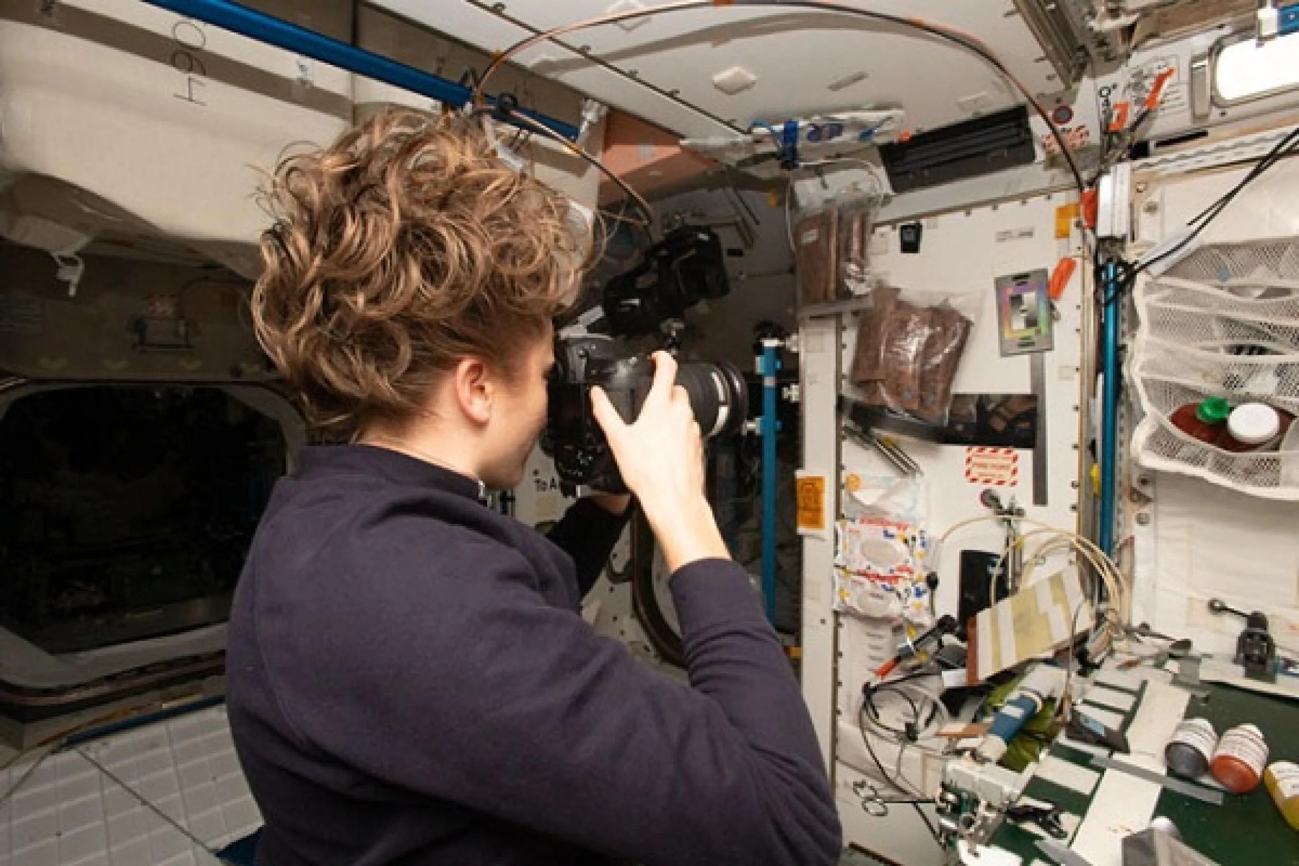 imagen de una astronauta tomando fotos del interior de la estación espacial