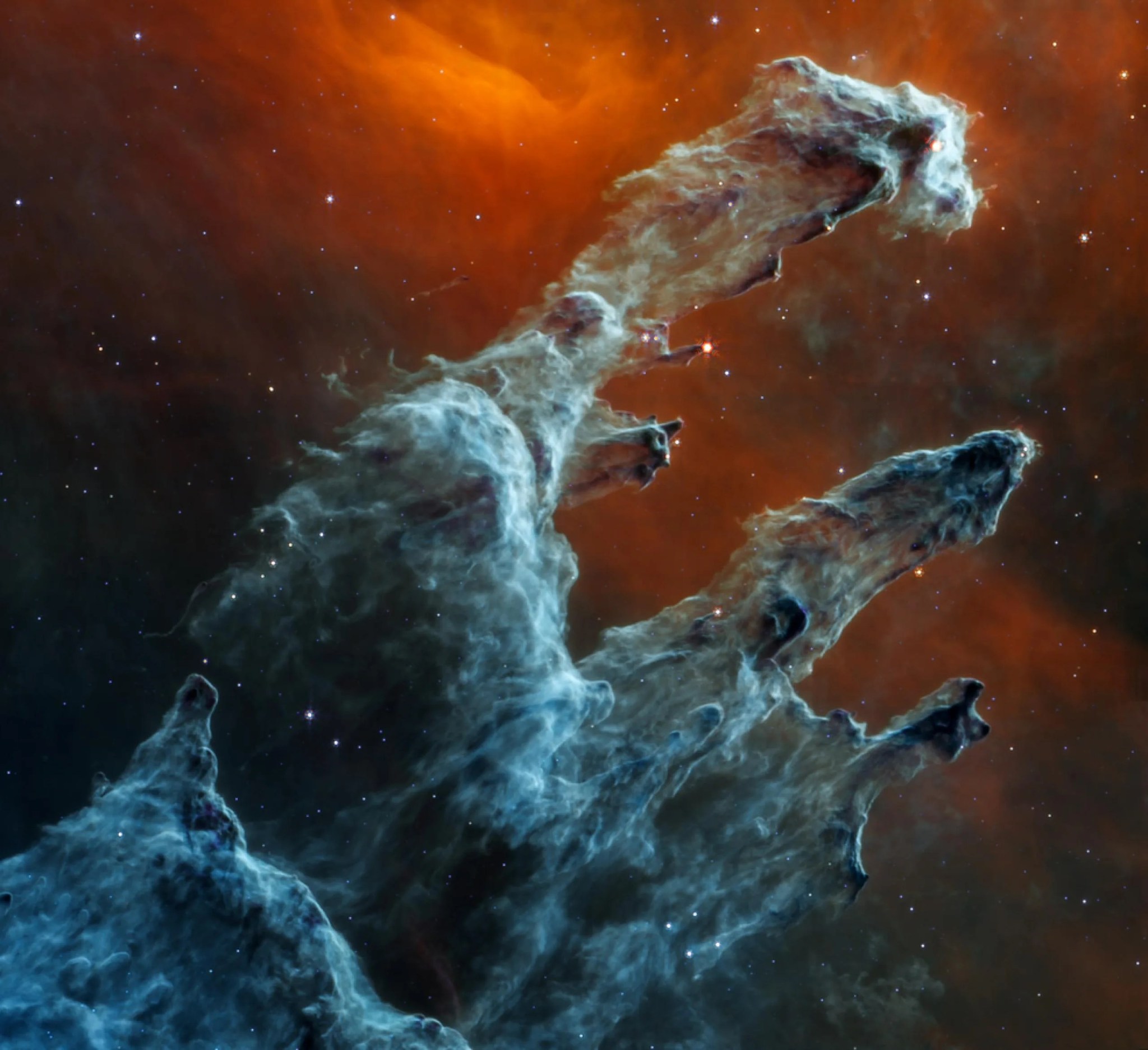 La vista del infrarrojo medio de los Pilares de la Creación captada por el telescopio espacial James Webb de la NASA tiene un tono escalofriante. Los miles de estrellas que existen en esta región parecen desvanecerse, ya que las estrellas normalmente no emiten mucha luz del infrarrojo medio y las capas aparentemente interminables de gas y de polvo pasan a ocupar el centro de la atención. La detección de polvo que lleva a cabo el instrumento de infrarrojo medio de Webb (MIRI) es extremadamente importante.