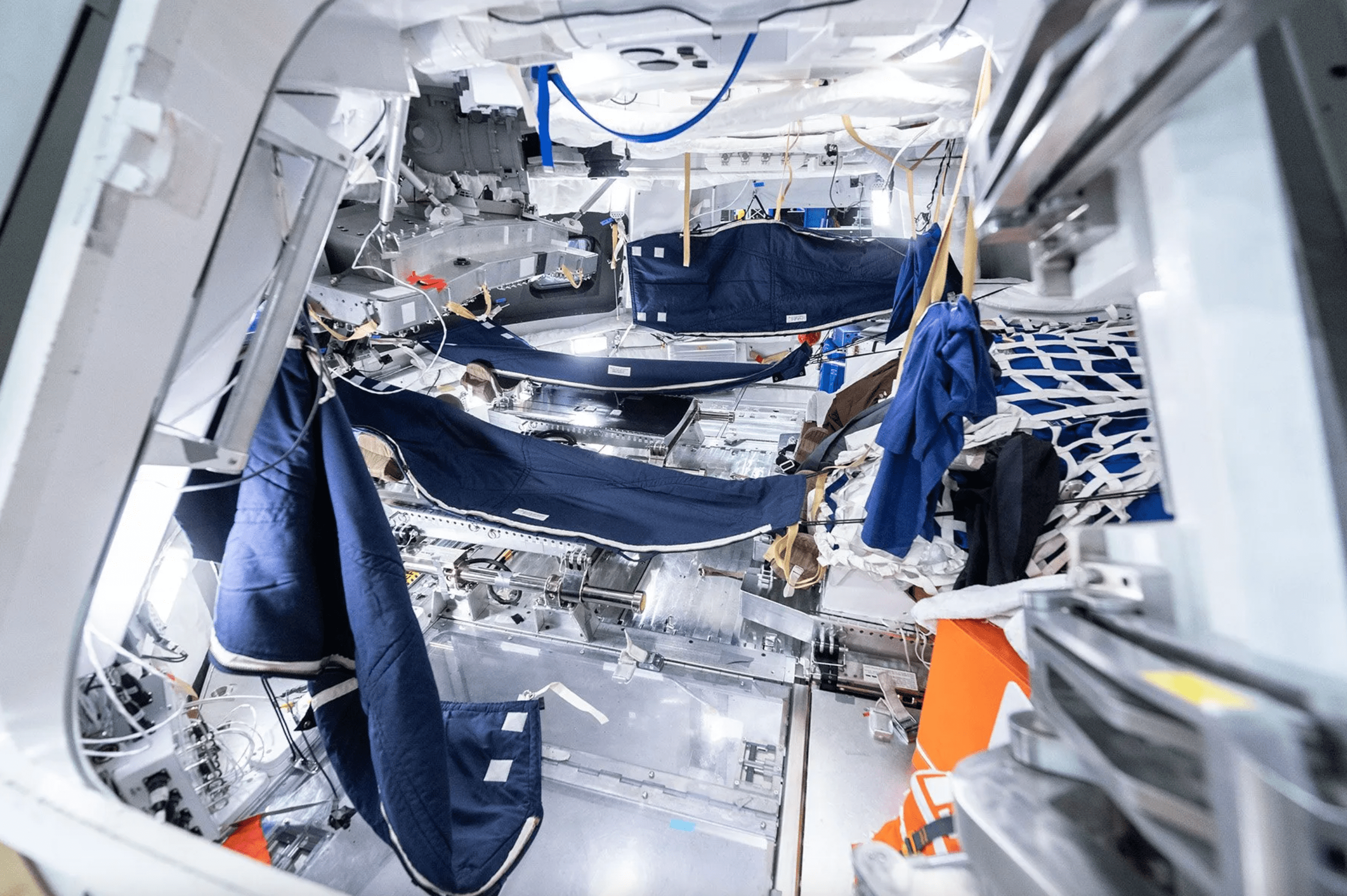 La foto muestra una de las configuraciones de los sacos de dormir azul oscuro de la tripulación de Artemis II dentro de la maqueta de fidelidad media de la nave espacial Orion en el Centro Espacial Johnson de la NASA en Houston.