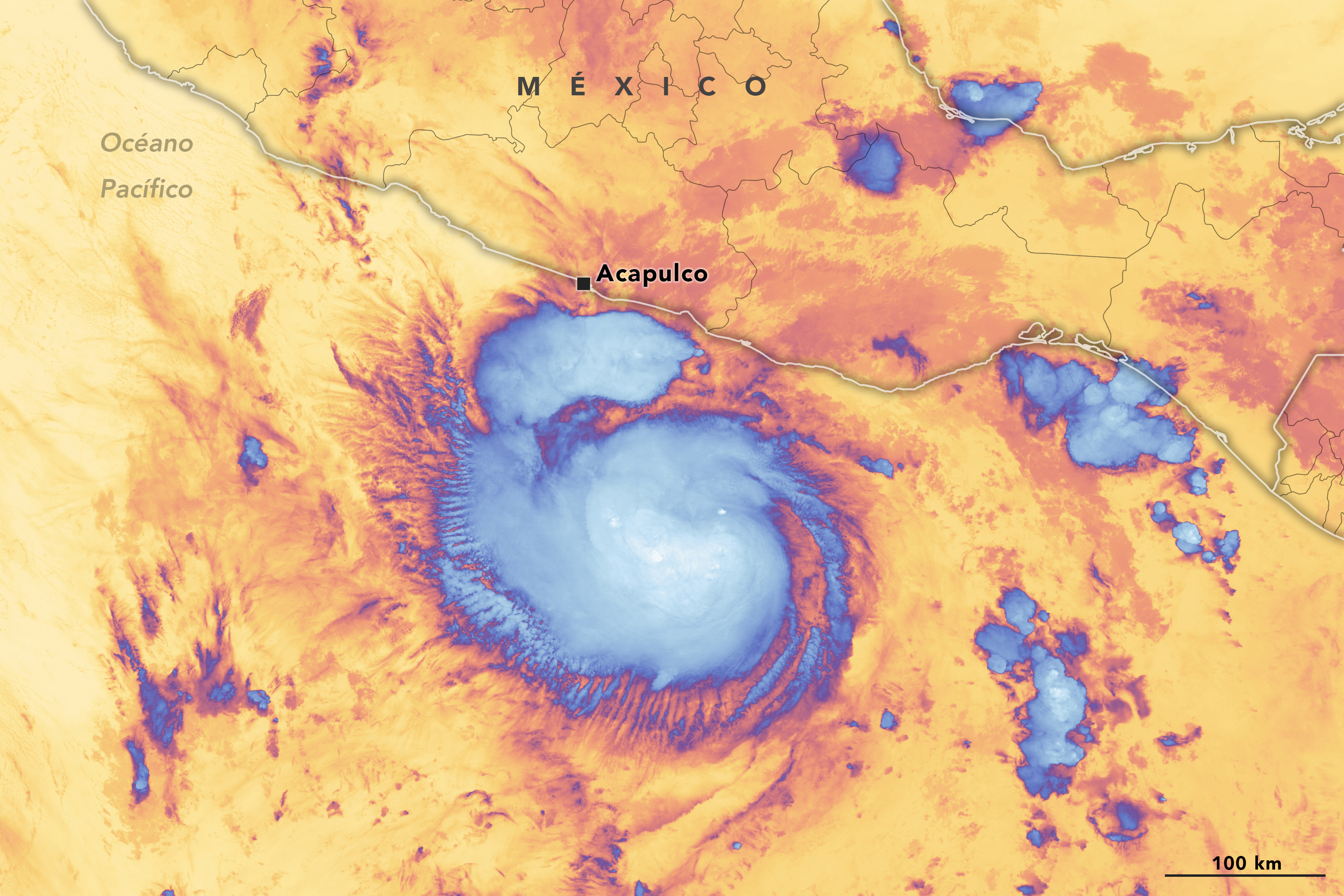 Imagen de satélite con color añadido del huracán Otis antes de tocar tierra. Una espiral azul brillante en el centro de la imagen indica estructuras de nubes más frías. Otras manchas azules más pequeñas rodean la espiral. El resto de la imagen es mayoritariamente amarilla con manchas naranjas. El amarillo indica superficies más cálidas por debajo. La costa del Pacífico de México aparece en gris.