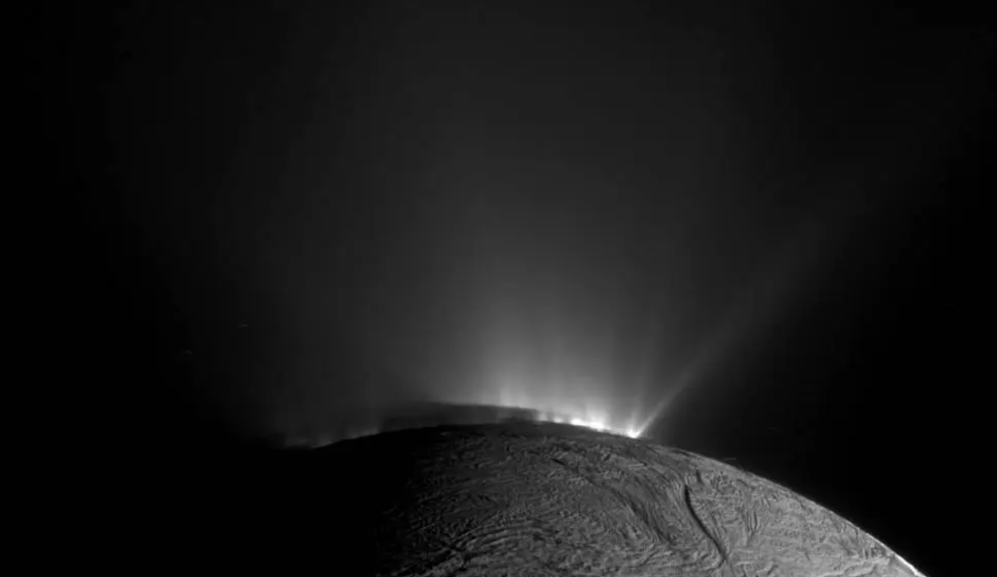La sombra de Encélado sobre las partes inferiores de los géiseres es claramente visible en esta imagen en blanco y negro captada por la sonda Cassini de la NASA.
