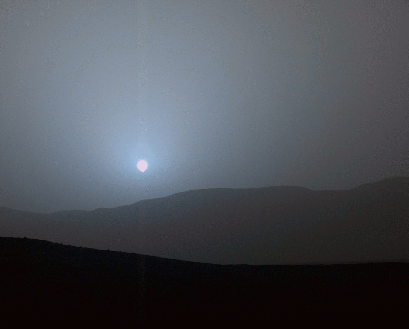 El explorador Curiosity de la NASA observa el Sol cuando se hunde bajo el horizonte en el cráter Gale en 2015.