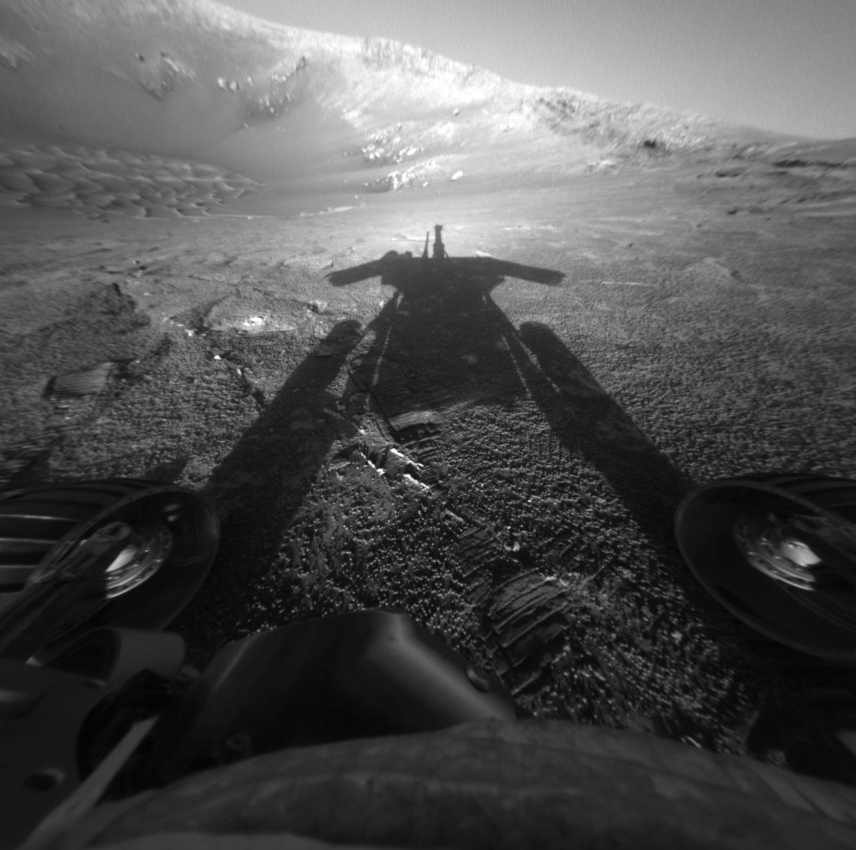 Esta imagen en blanco y negro muestra una vista captada por el rover en Marte Opportunity de su propia sombra el 26 de julio de ese año, el día marciano, o sol, número 180 de su misión.