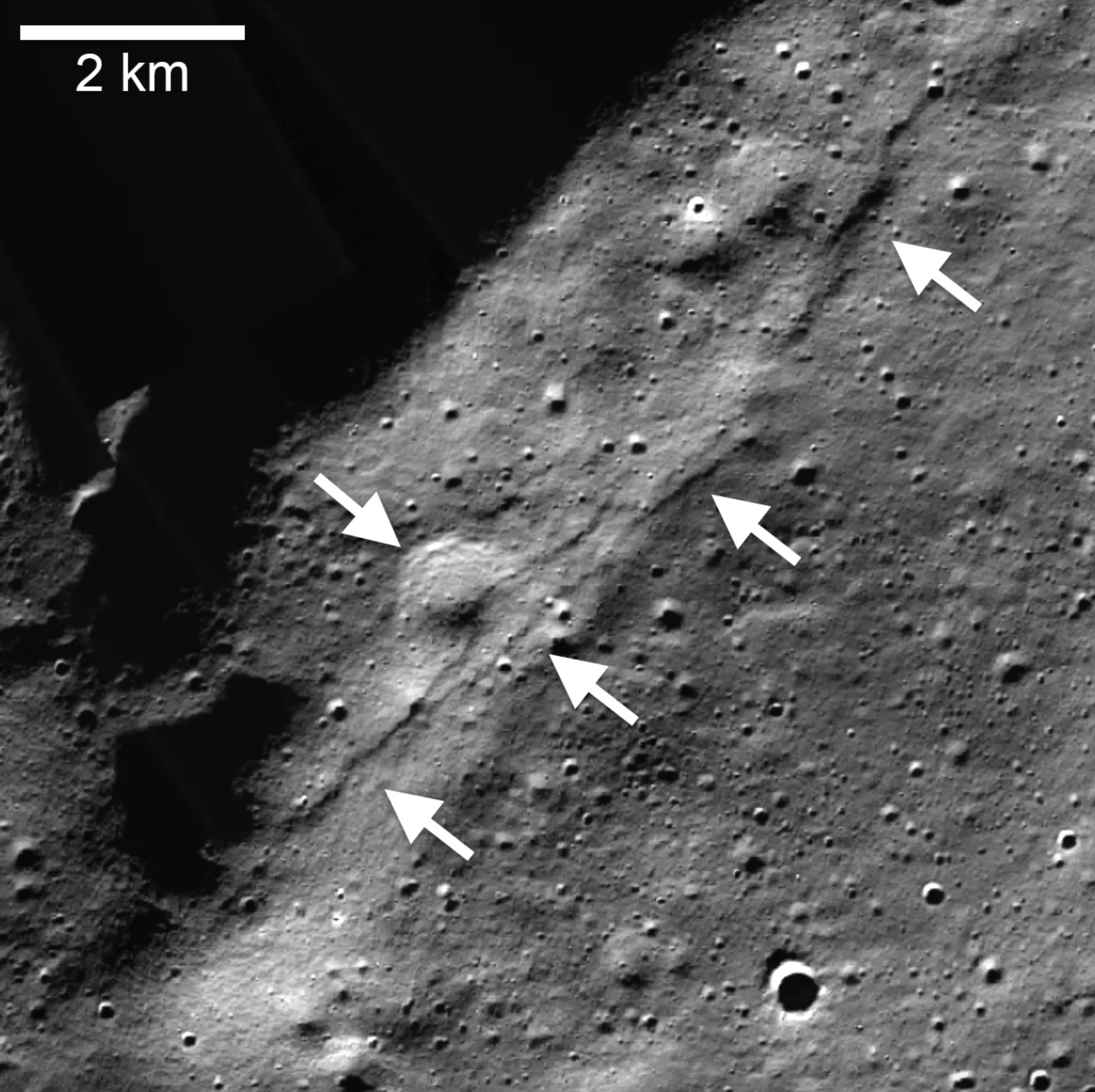 Mosaico del cúmulo de escarpes lobulados del cráter Wiechert (flechas que apuntan a la izquierda) cerca del polo sur lunar, con imágenes tomadas por la cámara de ángulo estrecho (NAC) de la cámara del Orbitador de Reconocimiento Lunar (LROC). Un escarpe de falla de cabalgamiento atravesó un cráter degradado de alrededor de 1 kilómetro (0,6 millas) de diámetro (flecha que apunta a la derecha).