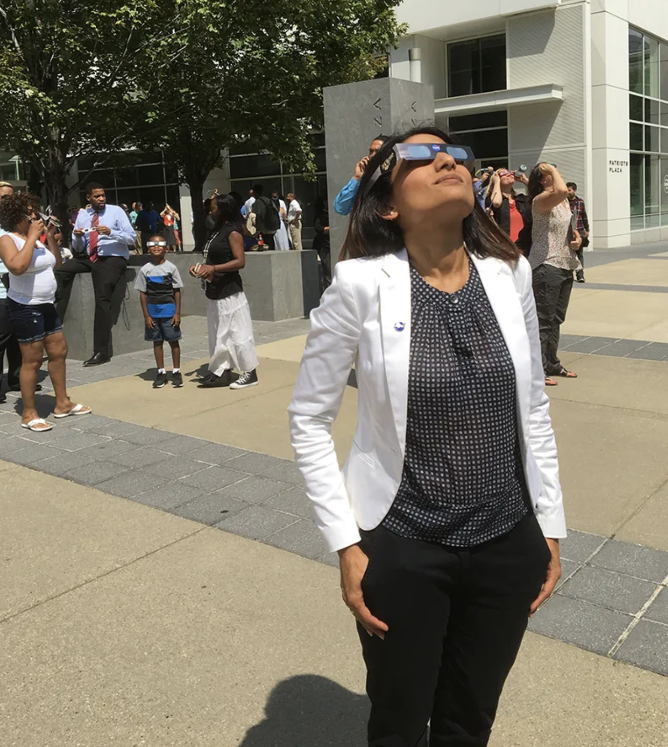 Una mujer observa un eclipse solar a través de anteojos especiales para eclipses.