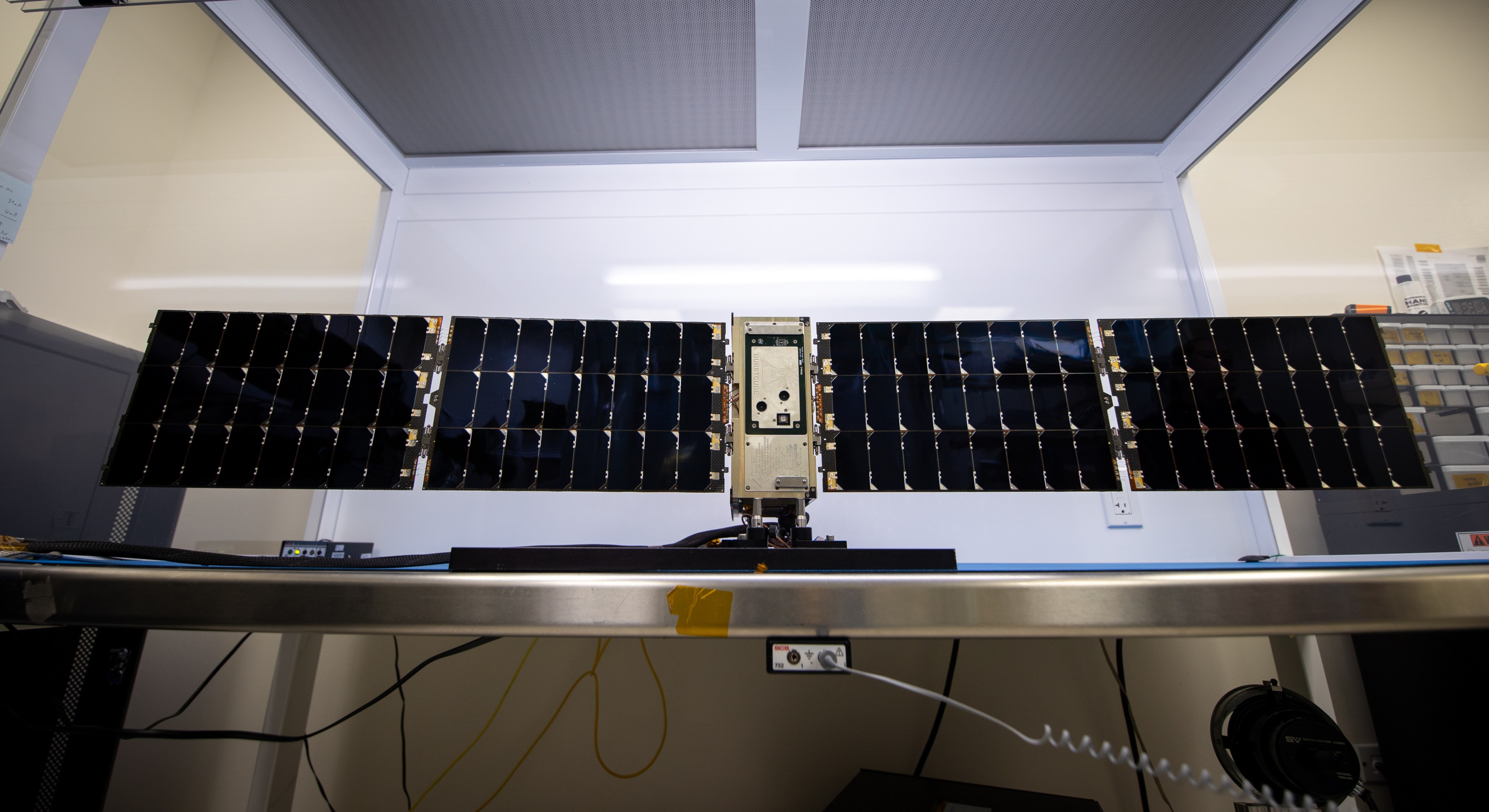El satélite BurstCube está sobre una mesa con sus paneles solares extendidos.