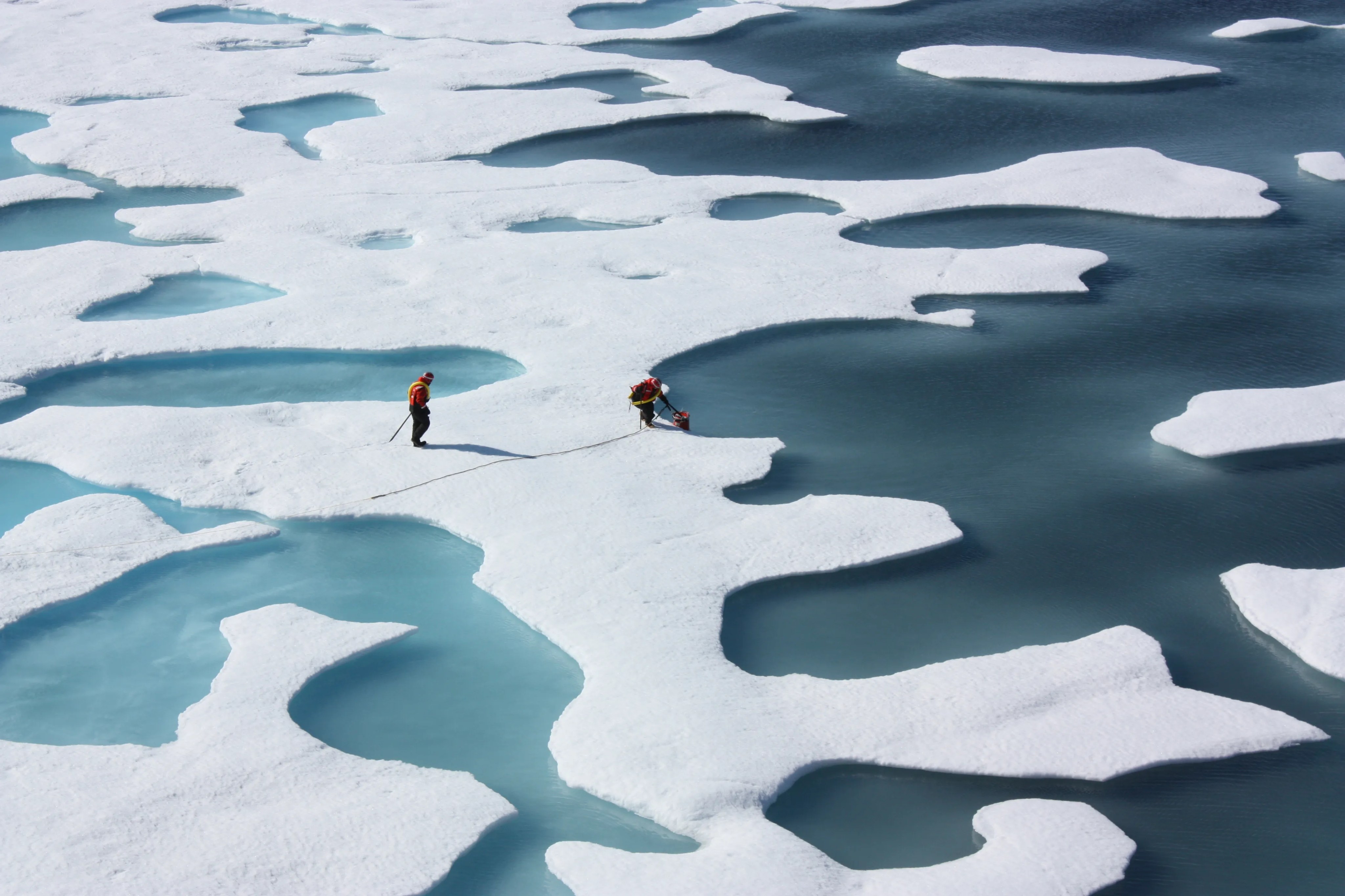 Miembros de un equipo científico recuperan un contenedor de estanques de derretimiento del océano Ártico.