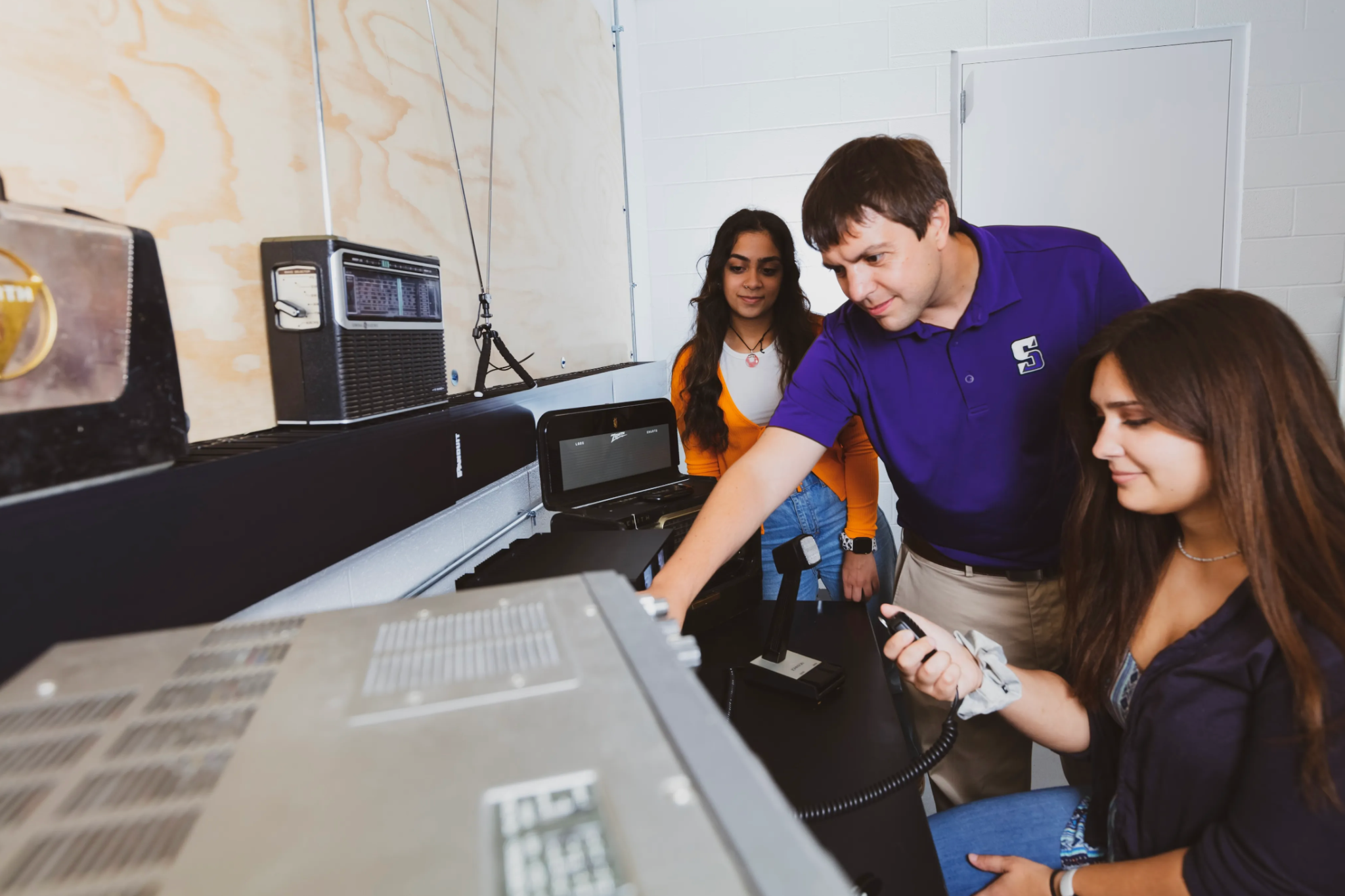 Dos estudiantes trabajan con el doctor Frissell en el laboratorio de radioaficionados de la ciudad universitaria.