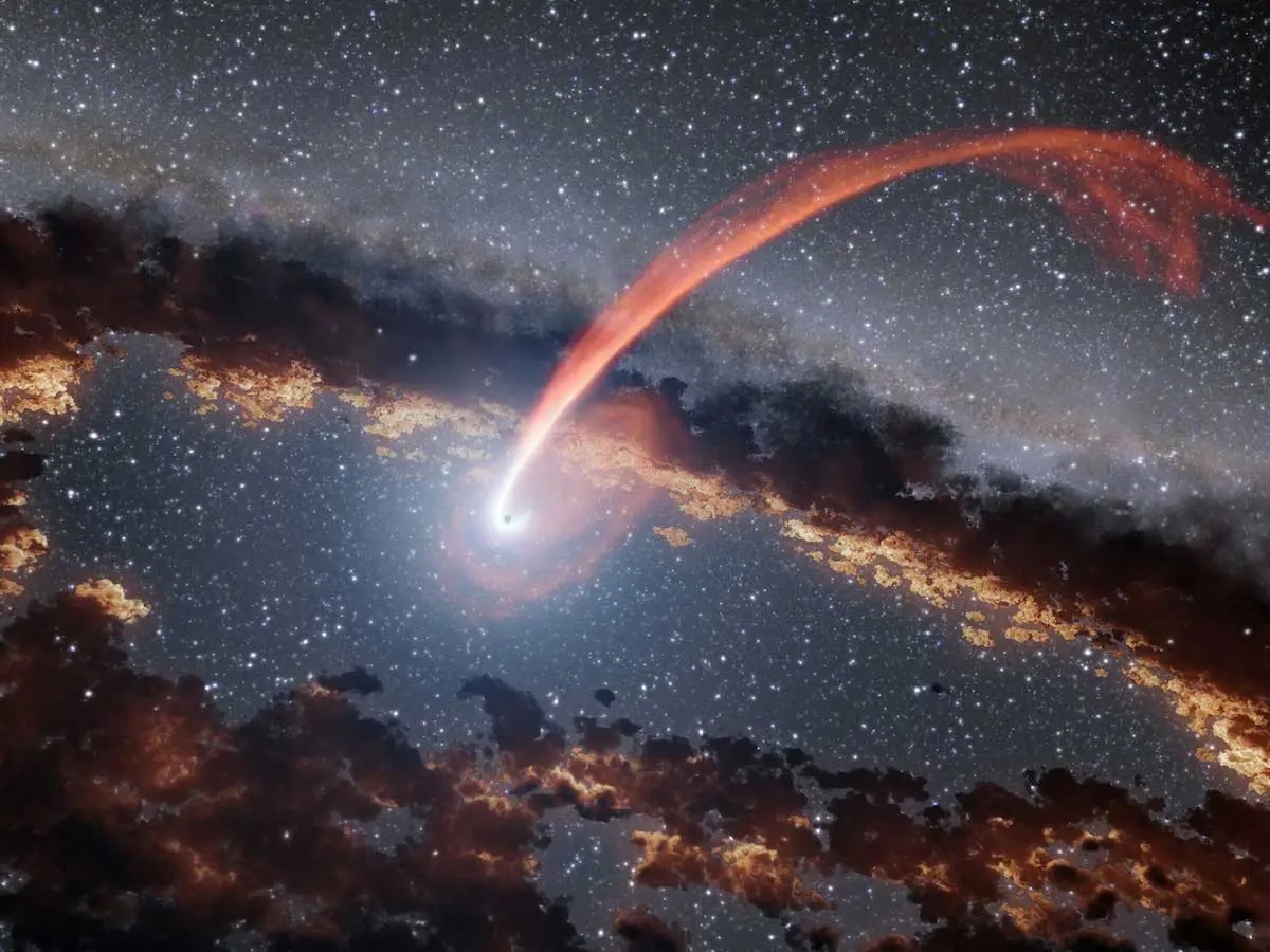 Esta ilustración muestra una corriente brillante de material procedente de una estrella hecha pedazos mientras era devorada por un agujero negro supermasivo. El agujero negro está rodeado por un anillo de polvo. Cuando una estrella pasa lo suficientemente cerca como para ser tragada por un agujero negro, el material estelar se estira y comprime a medida que es atraído, liberando una enorme cantidad de energía.