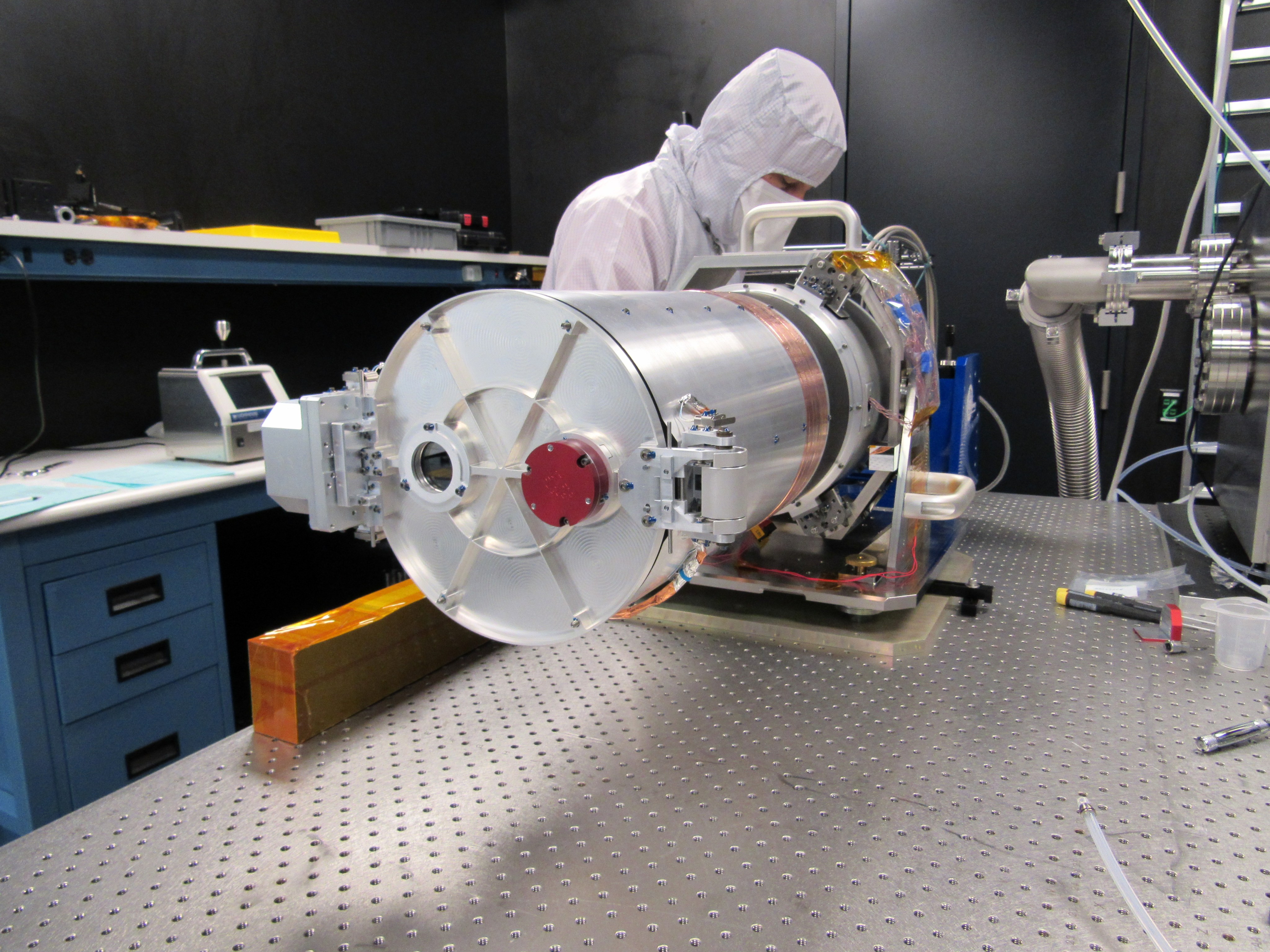 Un ingeniero del Laboratorio de Física Aplicada Johns Hopkins en Laurel, Maryland, inspecciona la configuración de prueba del montaje del telescopio óptico, parte de la cámara de ángulo estrecho del sistema de formación de imágenes de Europa Clipper.