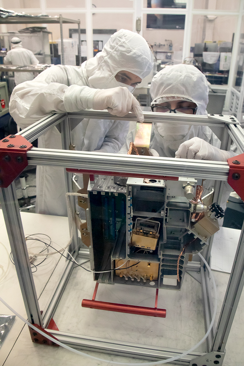 Brandon Pérez, ingeniero mecánico, y Bryan Esquivel, técnico, del Instituto de Investigaciones del Sudoeste (SwRI), se preparan para instalar placas eléctricas en el espectrógrafo de luz ultravioleta de Europa Clipper.