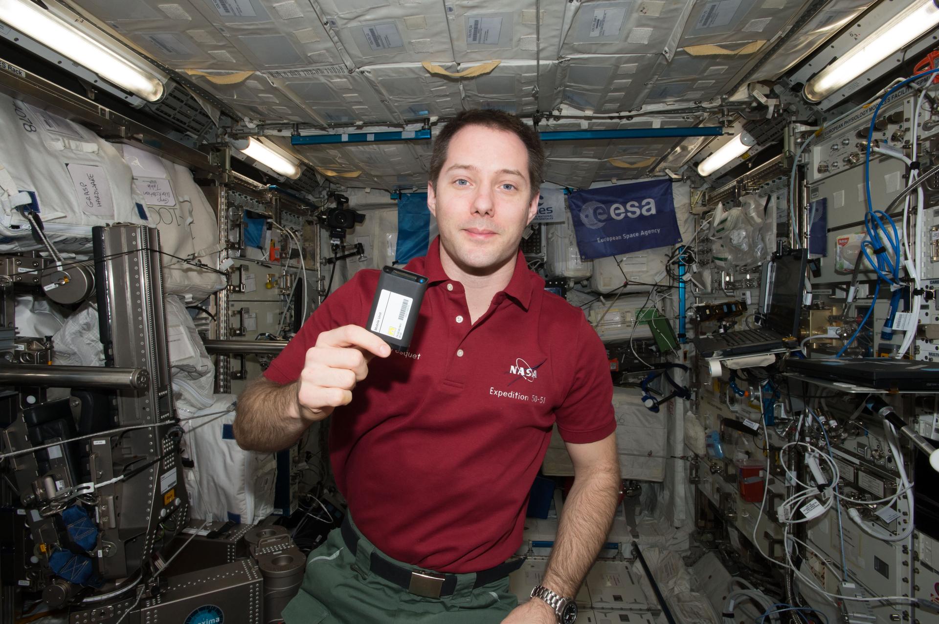 El astronauta de la ESA (Agencia Espacial Europea) Thomas Pesquet sostiene una unidad móvil para el experimento ESA-Dosímetros-Activos.