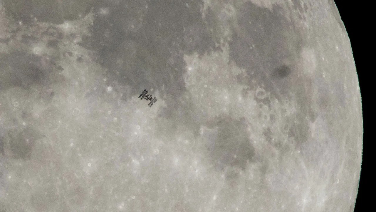 La silueta de la Estación Espacial Internacional, con seis tripulantes a bordo, es vista mientras pasa frente a la Luna en 2018.