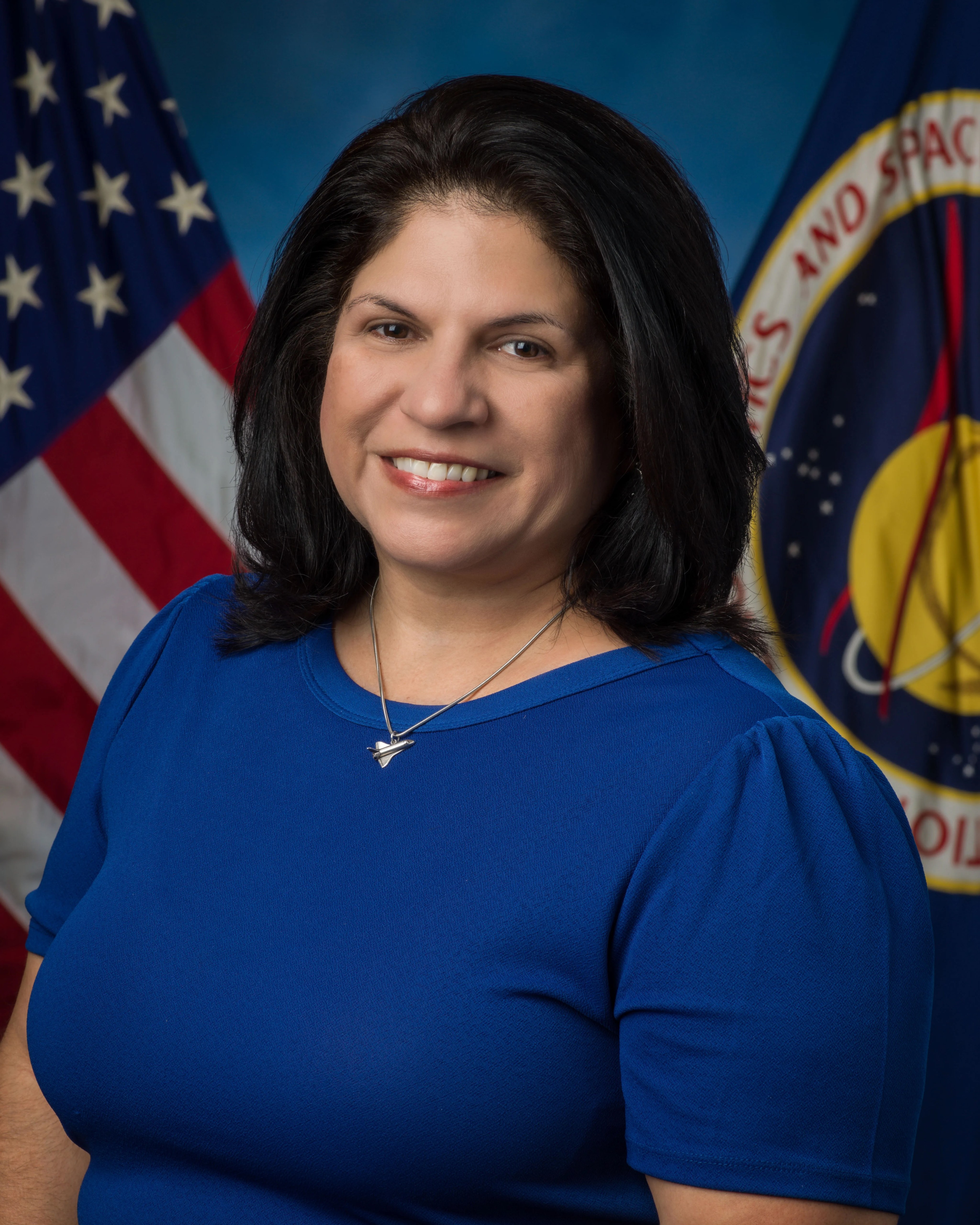 Retrato oficial de Jennifer Becerra, con un fondo azul y la bandera de Estados Unidos en el fondo.